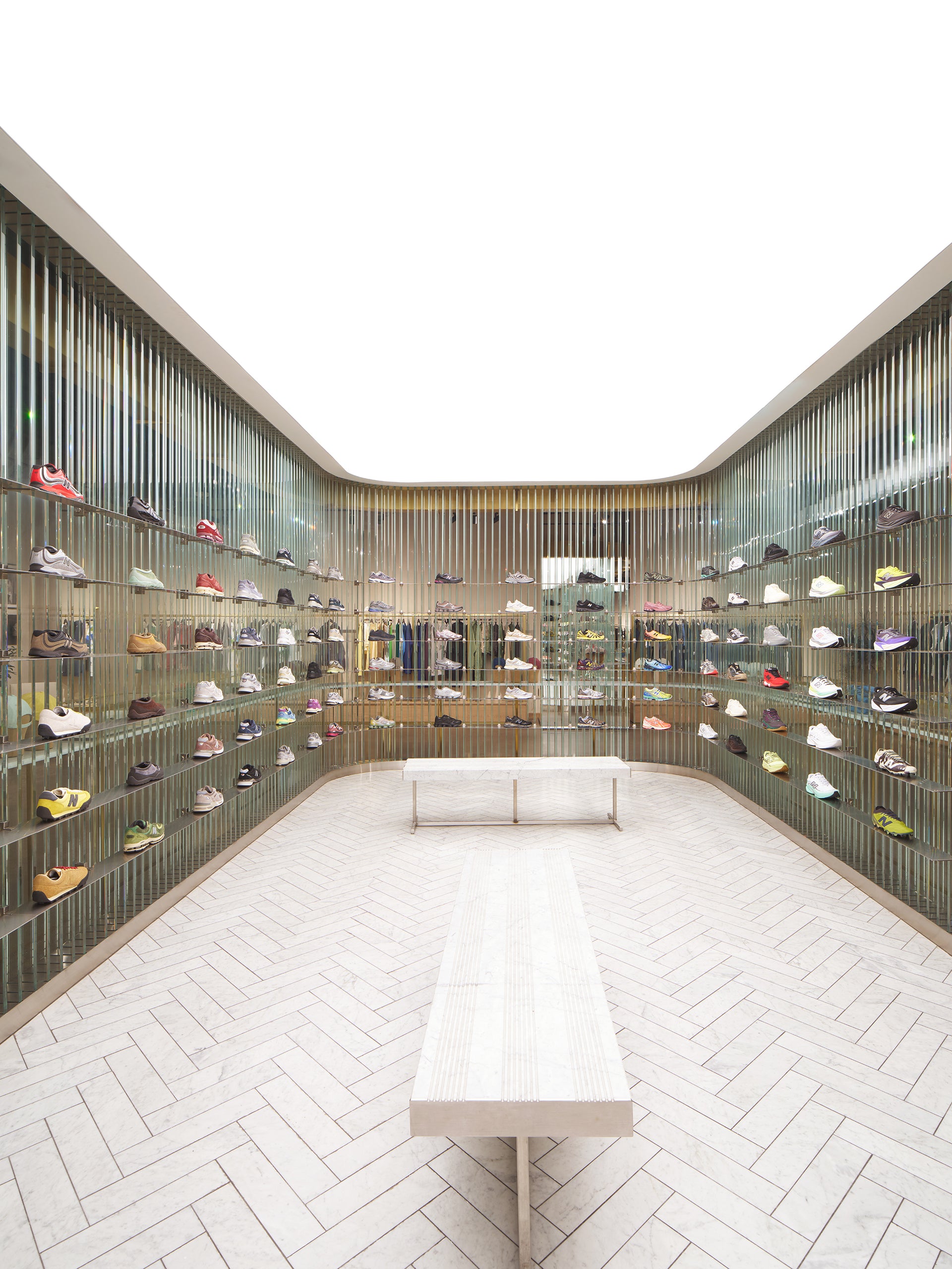 Kith store sneaker room with glass-rod display walls, marble benches and herringbone floor
