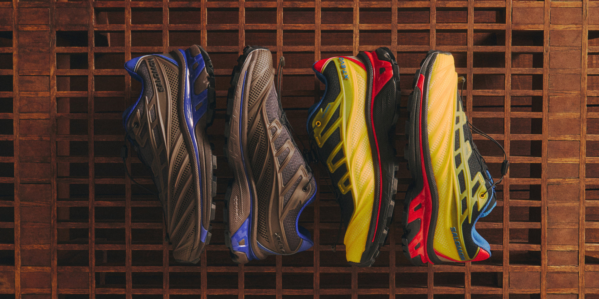 Four Salomon XT trail sneakers in profile on a wood grid, brown-and-blue and yellow-and-red colorways