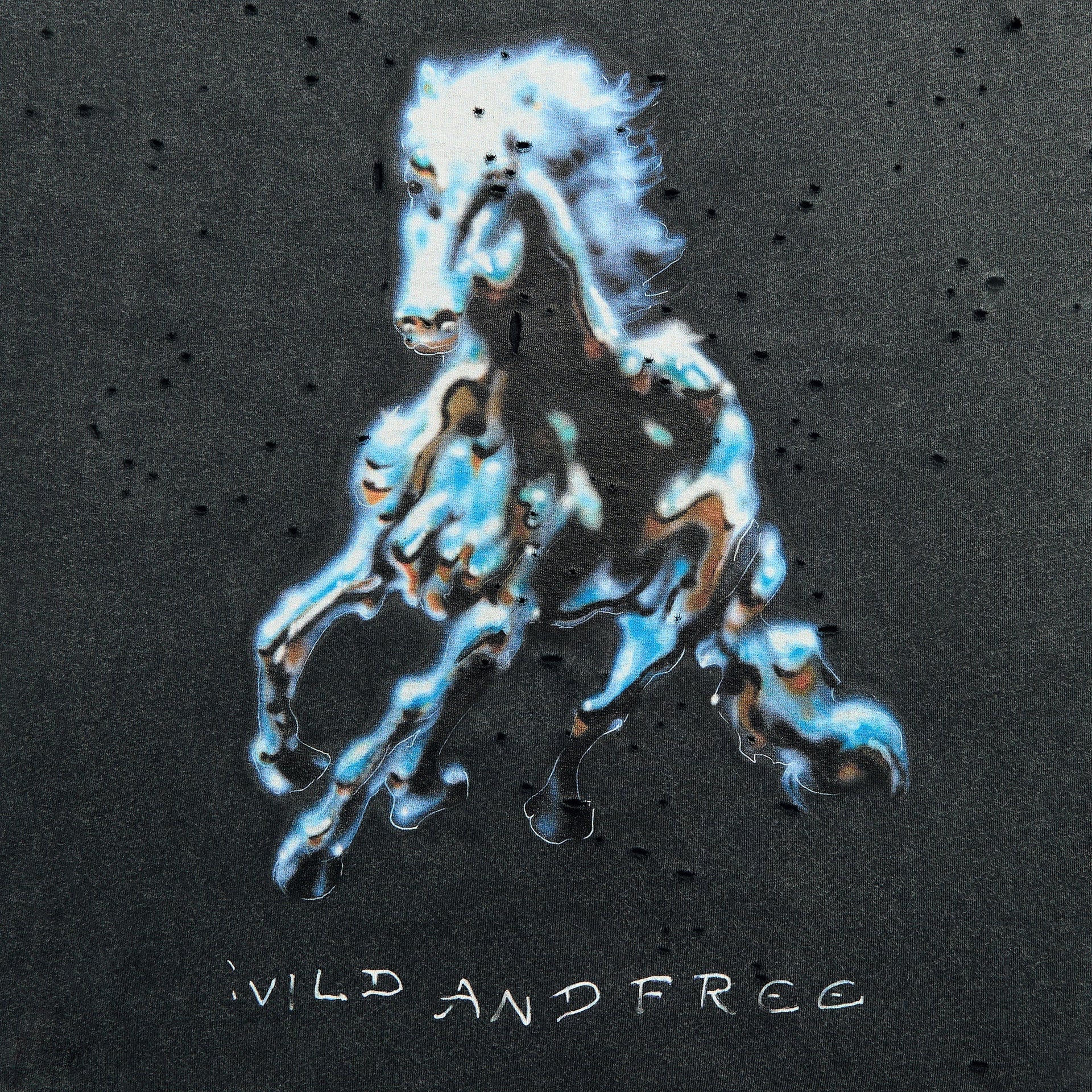 Close-up of the liquid-chrome galloping horse print and WILD AND FREE text on the Satisfy MothTech tee