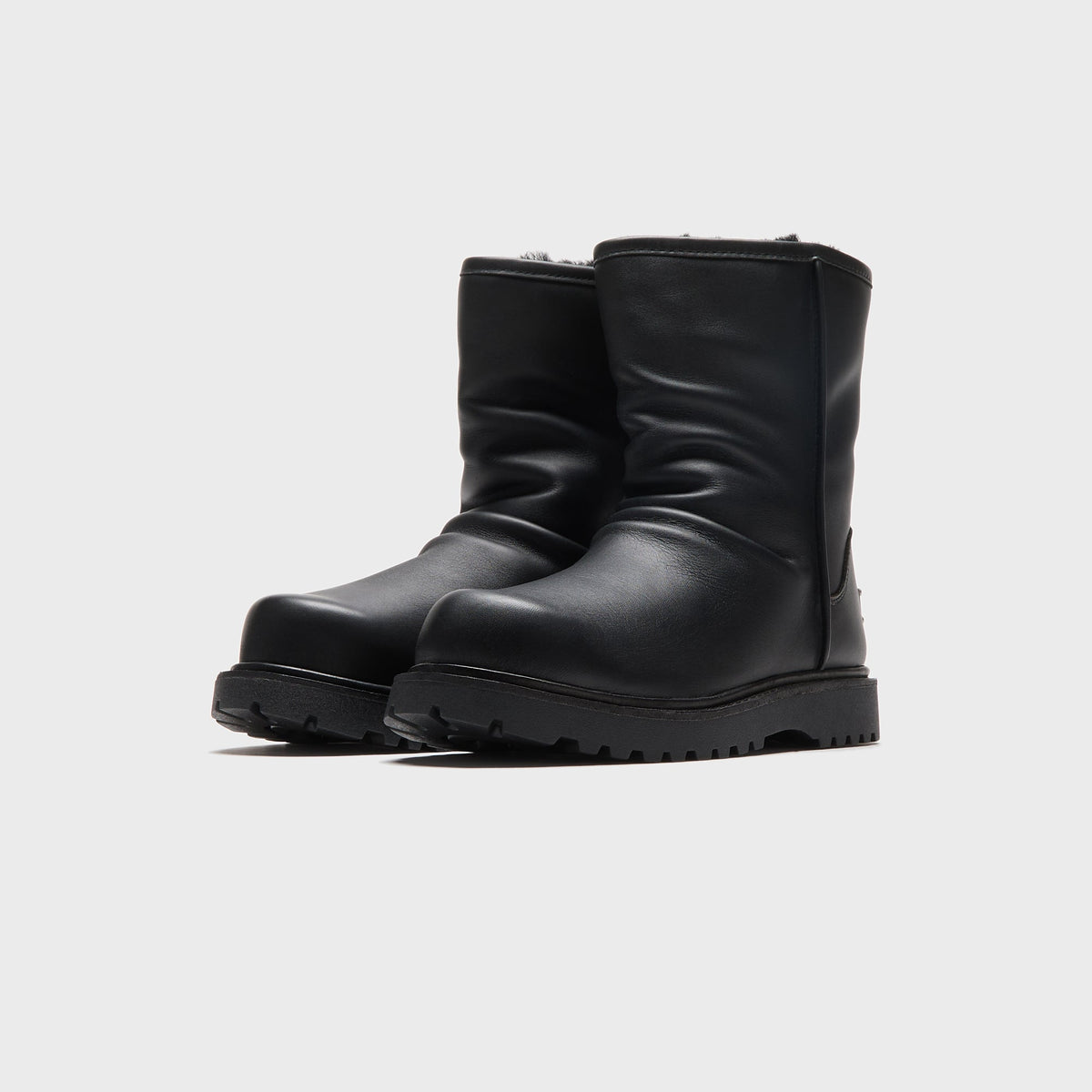 UGG x Willy Chavarria Relaxed Boot in Black leather, front three-quarter view of the pair