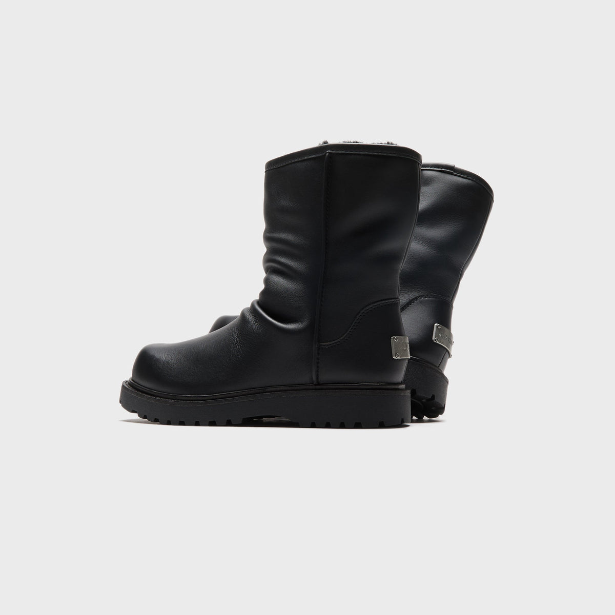 UGG x Willy Chavarria Relaxed Boot in Black leather, rear three-quarter view showing the branded heel hardware