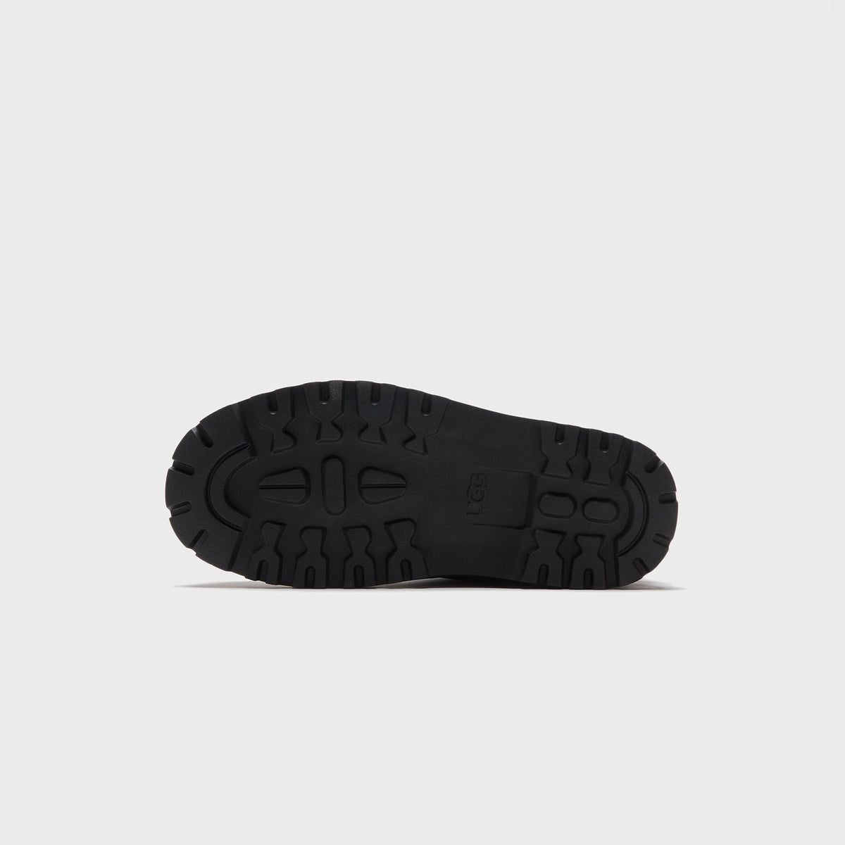 UGG x Willy Chavarria Relaxed Boot outsole in cream, close-up of the UGG logo lug tread pattern