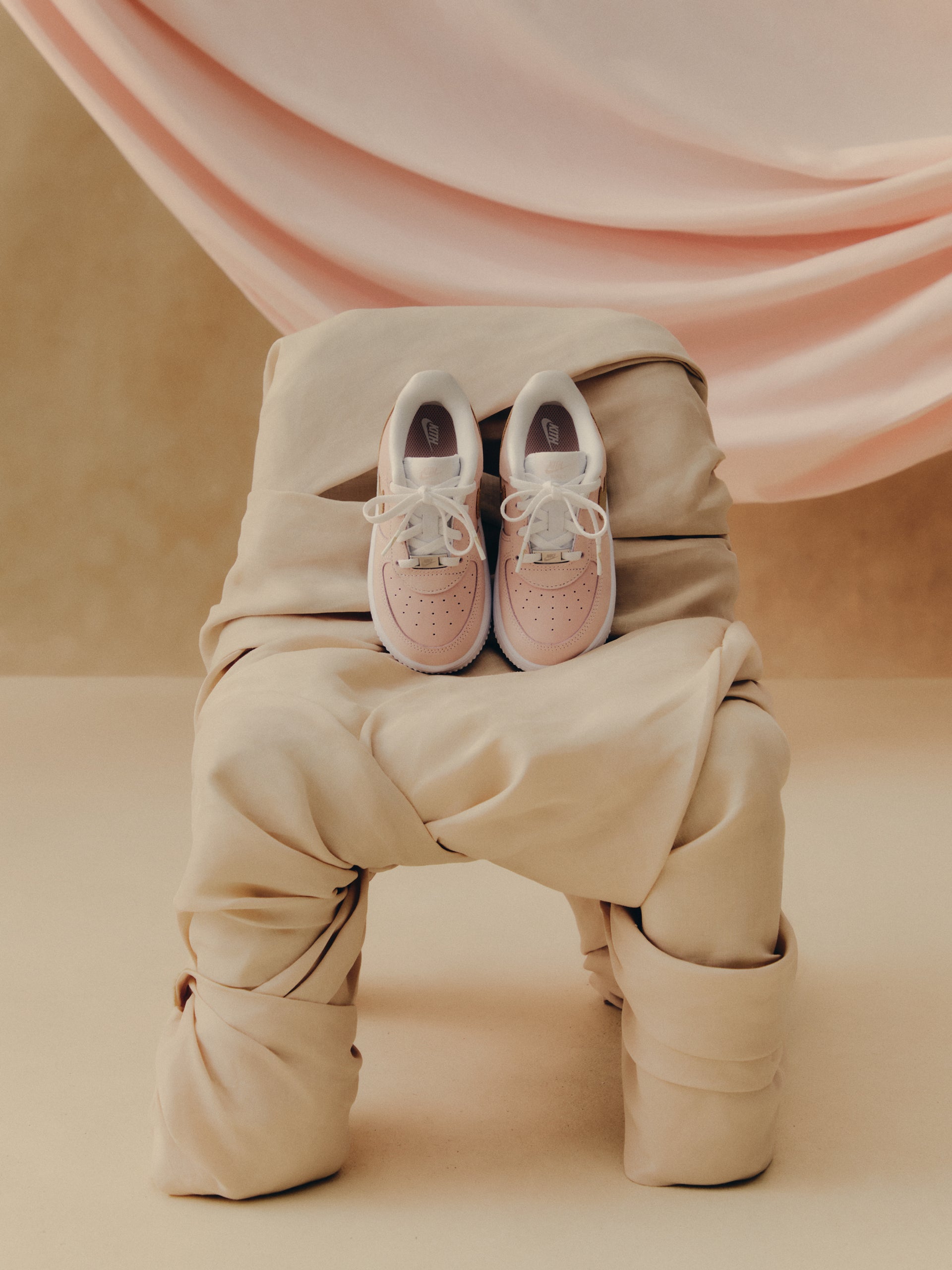 Kith x Nike Air Force 1 Low pair, pale pink, top-down view showing Nike and AIR tongue branding