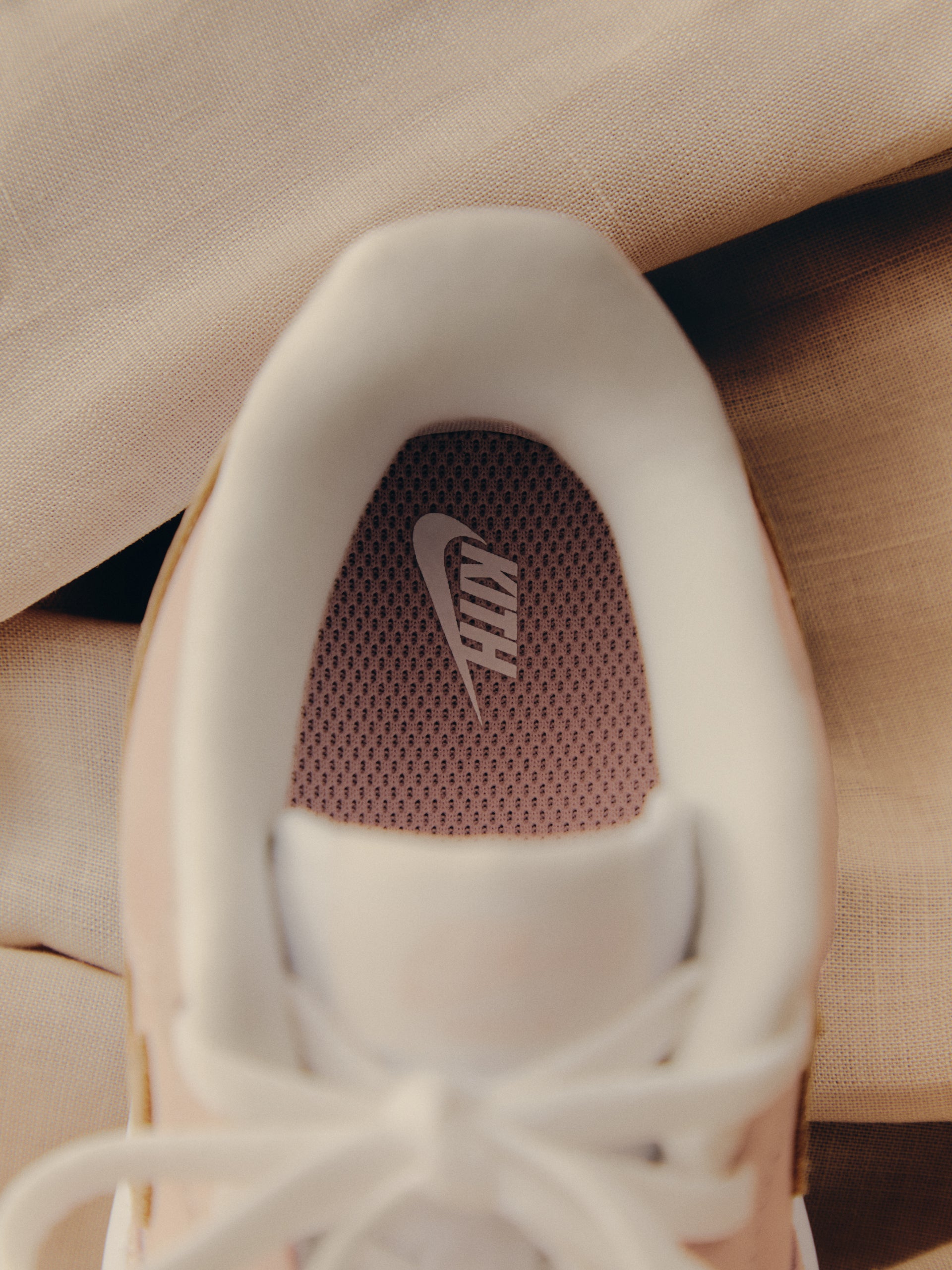 Close-up of Kith x Nike sneaker insole with co-branded KITH Swoosh on pink mesh