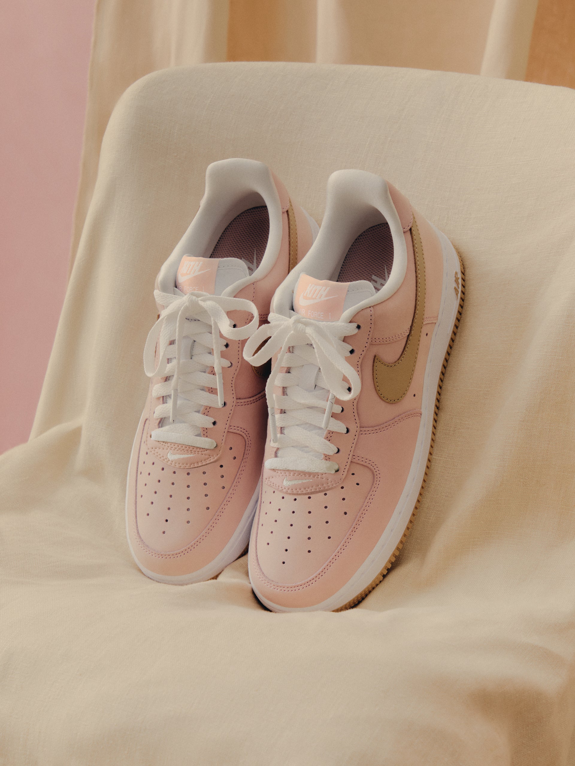 Kith x Nike Air Force 1 Low pair, pink with gold Swoosh, gum sole and KITH tongue branding, top view