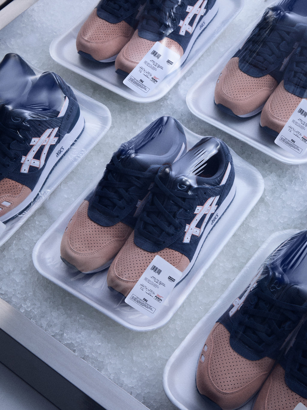 Kith for ASICS GEL-LYTE III sneakers in tan suede and navy, displayed in foam trays on ice, overhead angle