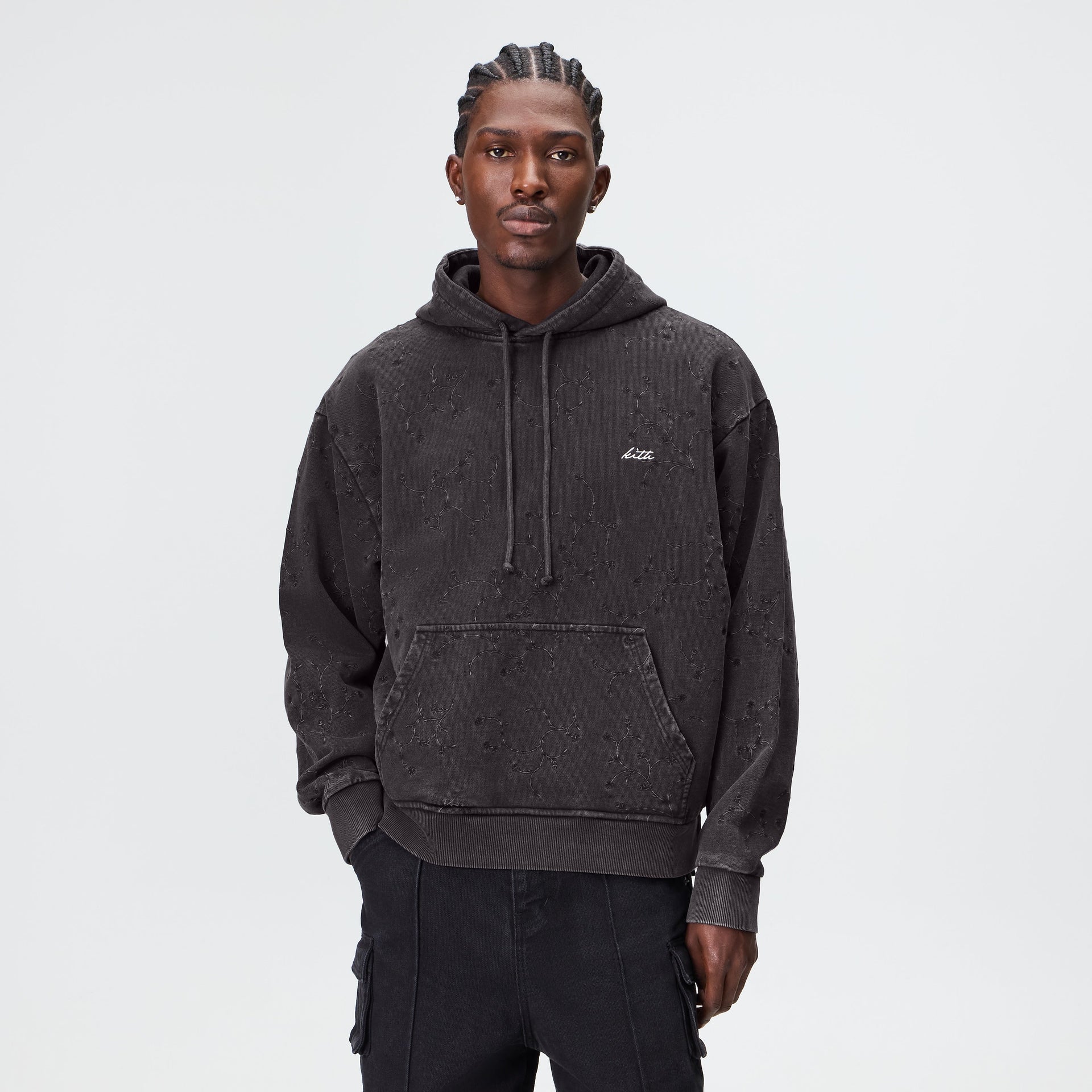 Man wearing the Kith Rose Ivy Nelson hoodie in faded black with drawstring hood