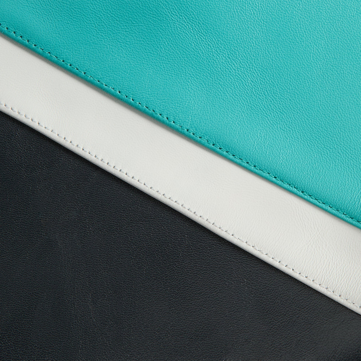 Kith & AVIREX for the Vancouver Grizzlies Jacket leather detail showing teal, cream stripe and black color-block panels with stitching