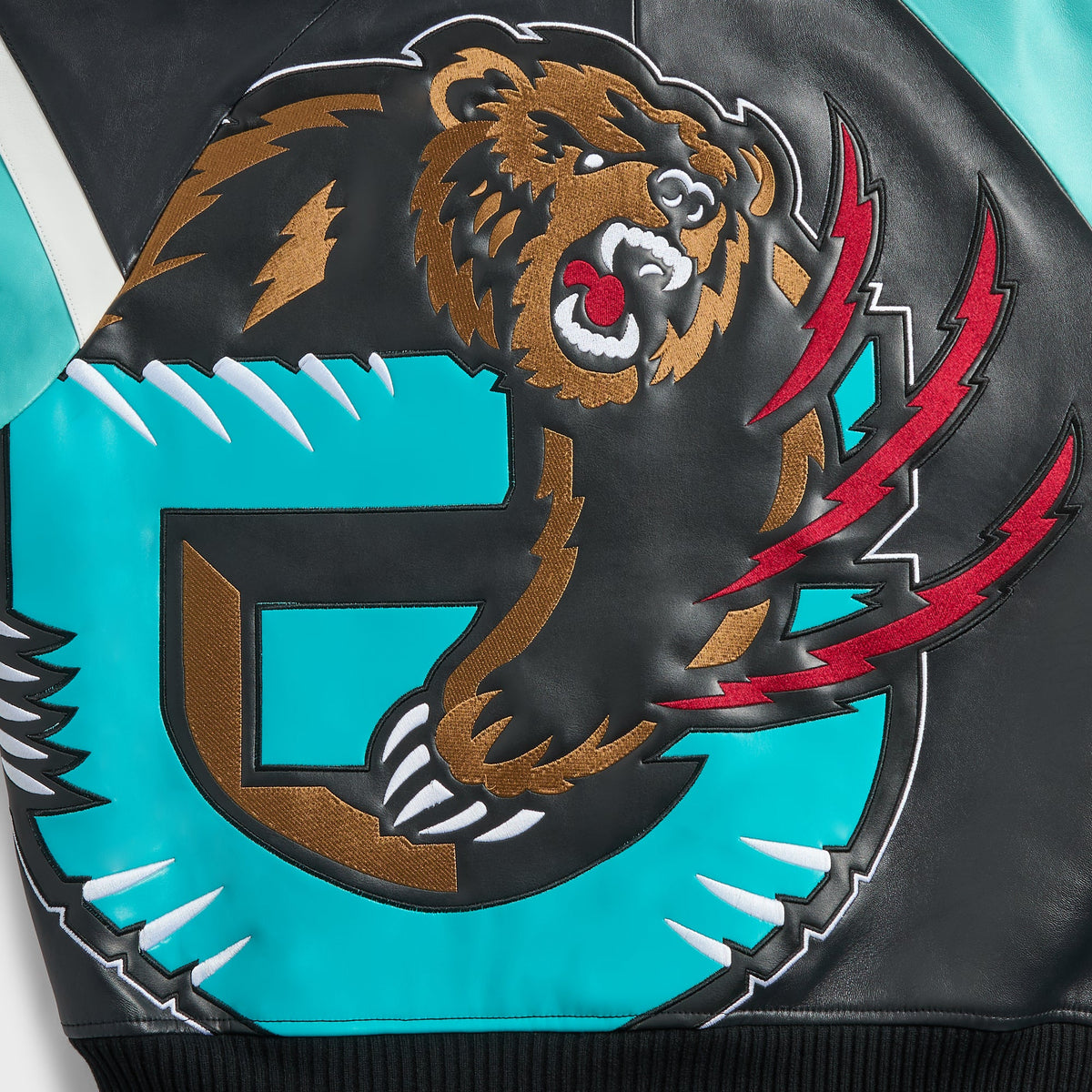 Kith & AVIREX for the Vancouver Grizzlies Jacket close-up of the back bear and teal G logo with red claw marks in textured appliqué