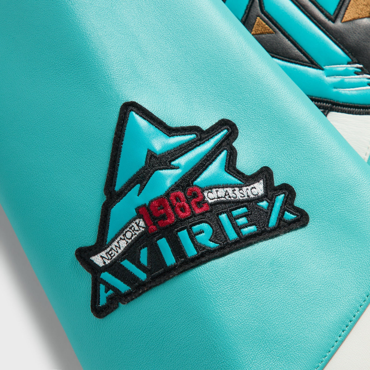 Kith & AVIREX for the Vancouver Grizzlies Jacket close-up of the Avirex 1982 Classic mountain patch on the teal leather sleeve