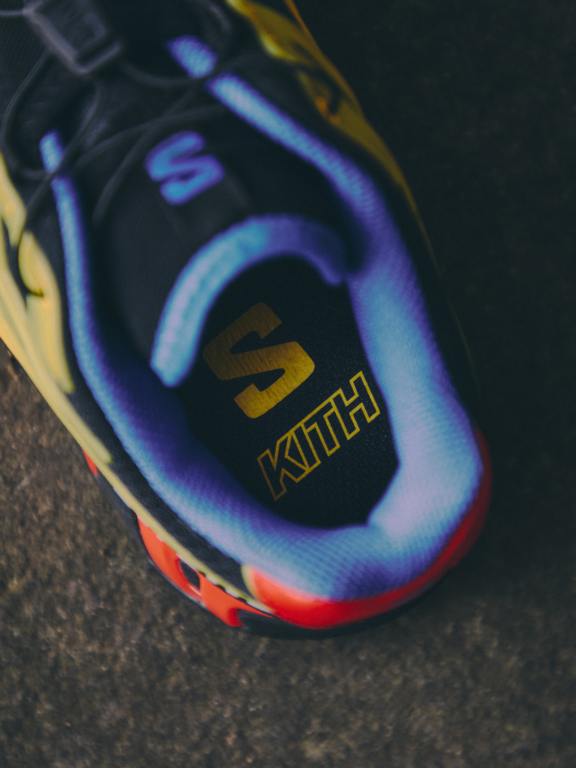 Close-up of Salomon x Kith sneaker insole with gold Salomon S and Kith logos, blue and yellow accents