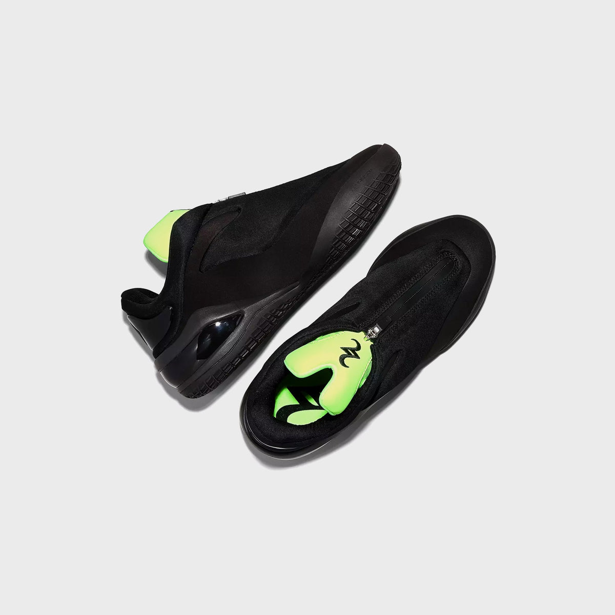 Converse SHAI 001 Ox pair in black, top-down view showing zip closure and green interior tongue
