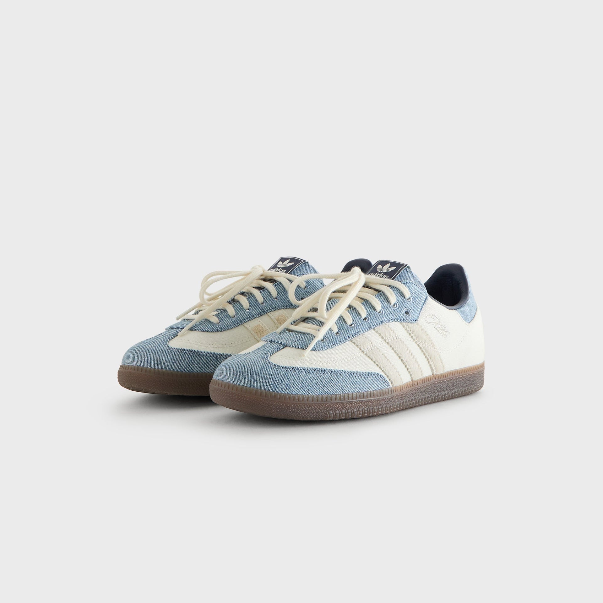 Kith for adidas Originals Samba sneakers in Denim/White, front three-quarter view of the pair with cream laces and adidas Trefoil tab