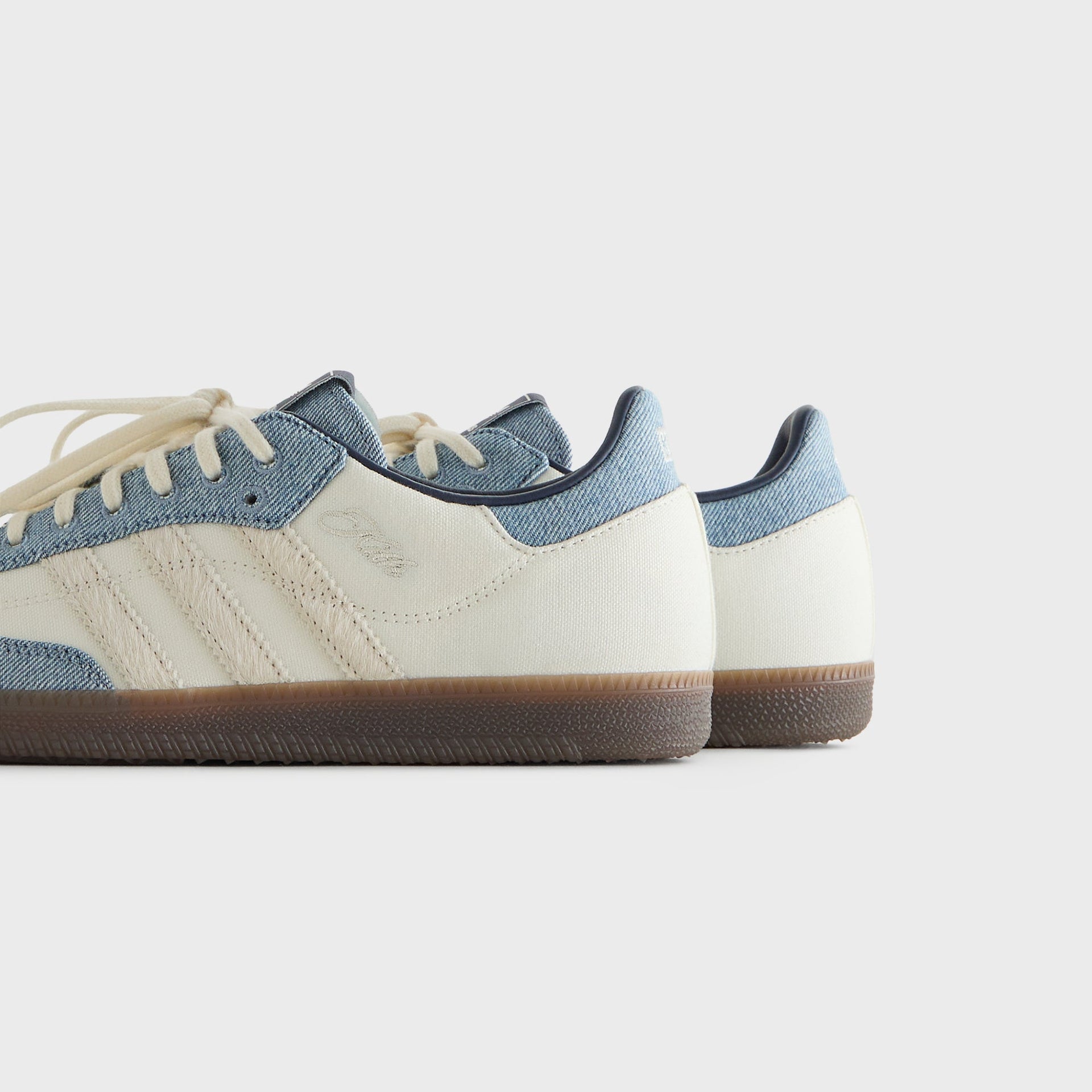 Heel view of Kith for adidas Originals Samba "Denim" sneakers showing the embroidered Kith script logo