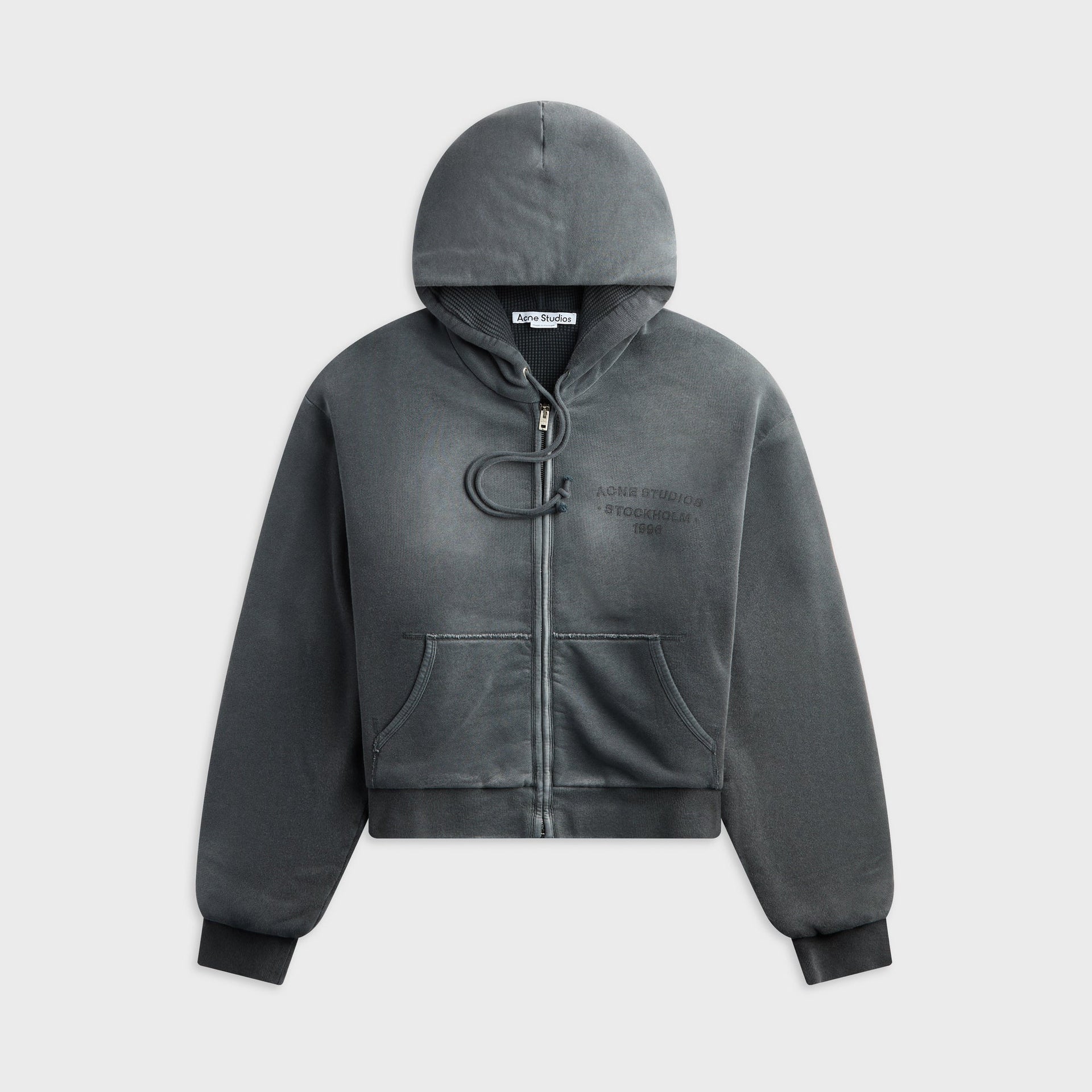 Acne Studios faded black zip hoodie, front view with drawstring hood and Stockholm 1996 embroidered logo, flat lay