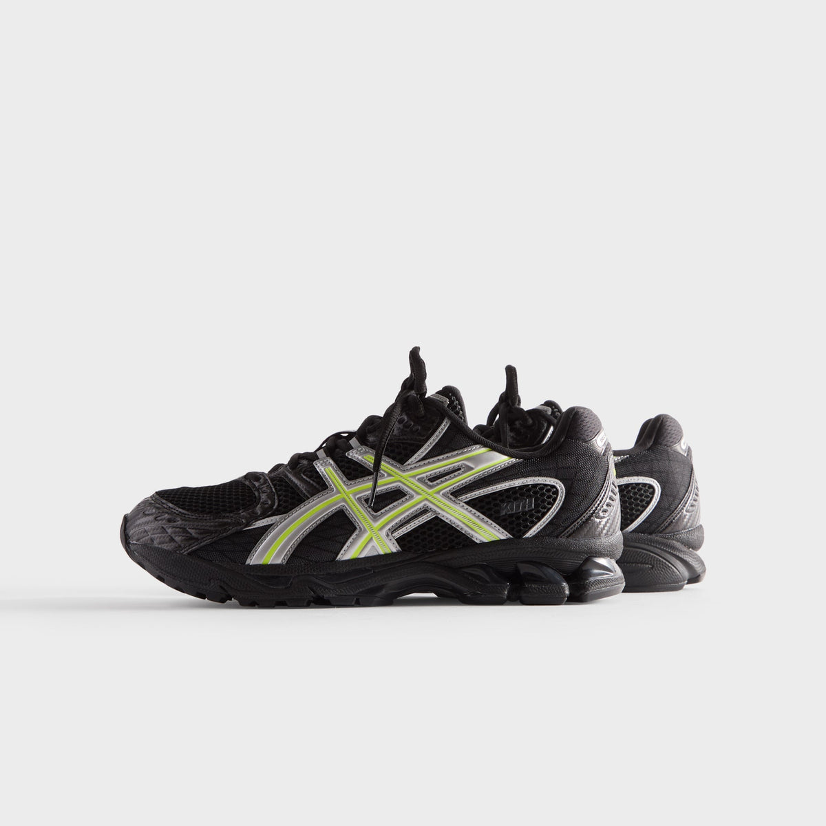 Kith for ASICS GEL-NIMBUS 10.1 black and silver, low side view of pair with silver stripes and lime accents on black sole