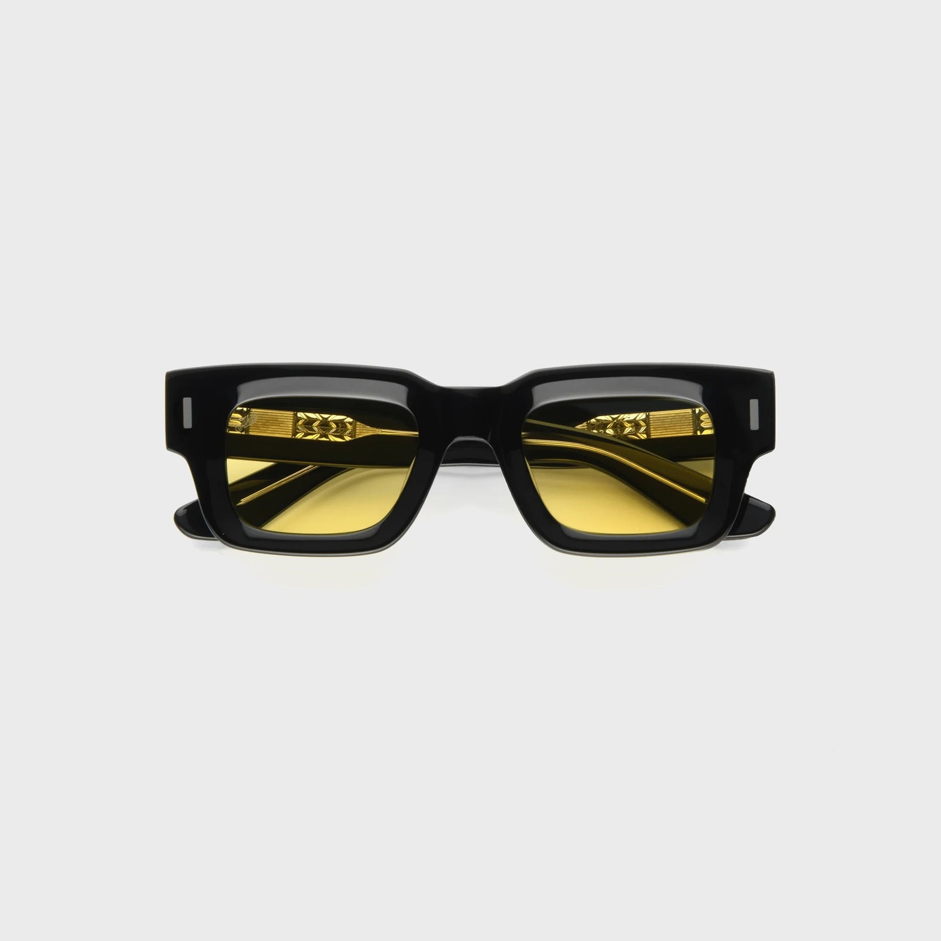 AKILA Ares sunglasses, front view, glossy black square acetate frame, yellow tinted lenses, gold engraved temple details