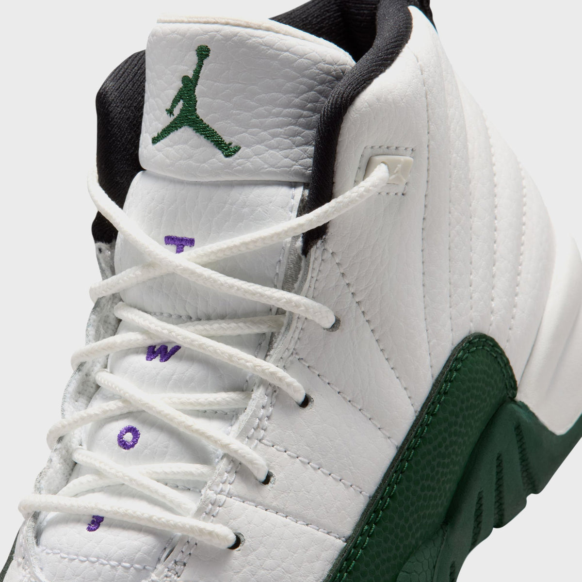 Close-up of Jordan PS Air Jordan 12 Retro preschool pair showing green Jordan Wings embroidery and purple lace text