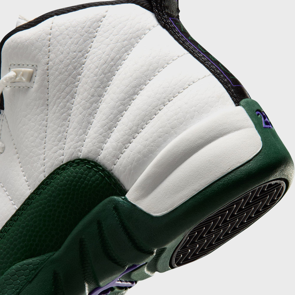 Close-up of Jordan PS Air Jordan 12 Retro preschool heel and outsole edge showing purple 23 branding on white and green