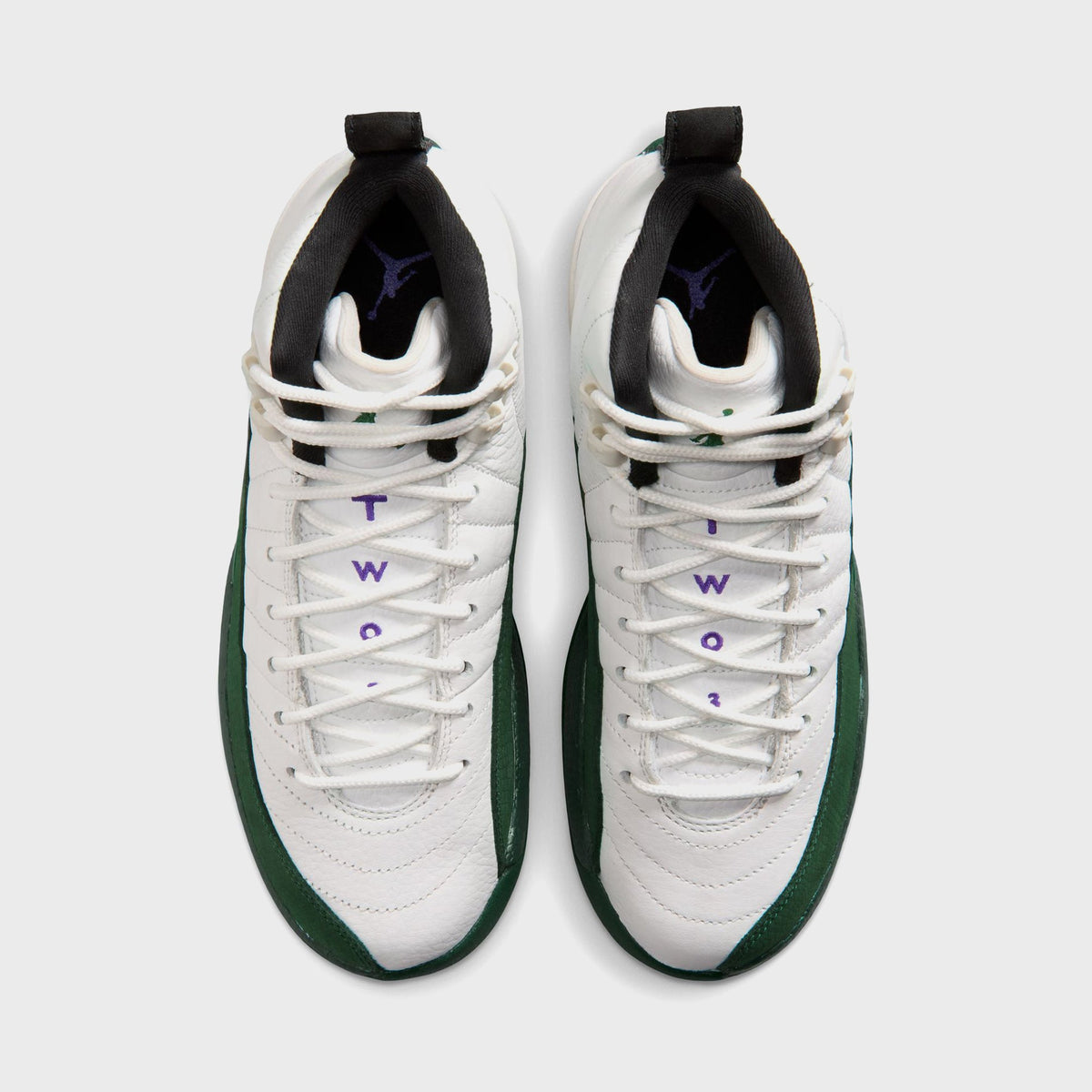 Top-down view of Jordan GS Air Jordan 12 Retro pair showing purple Jordan Wings embroidery and green pull tab