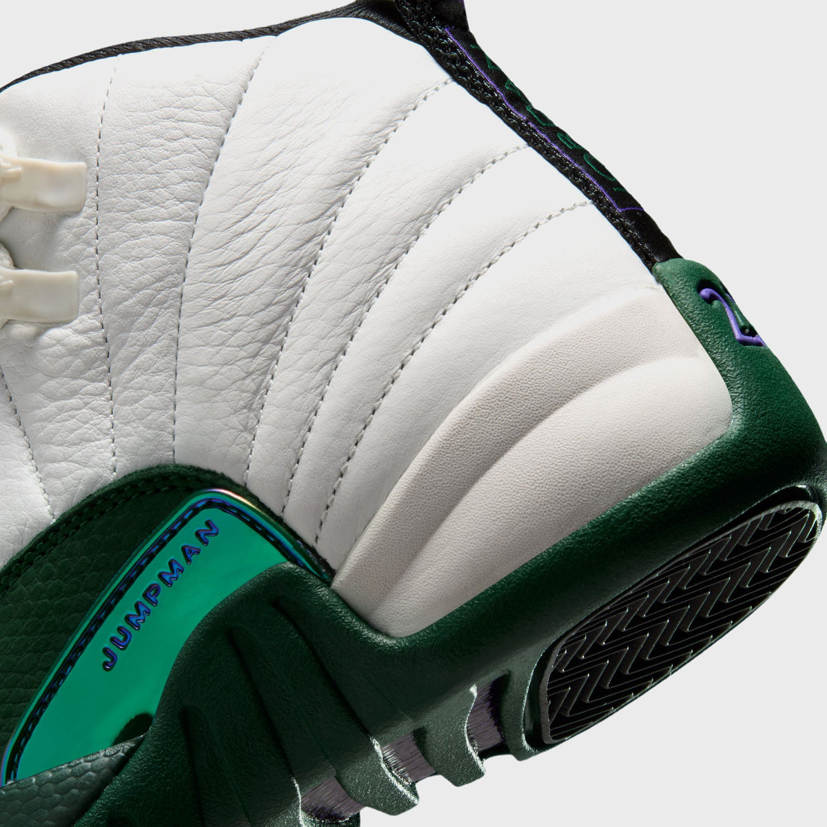 Close-up of Jordan GS Air Jordan 12 Retro heel showing purple 23 detail and iridescent green Jumpman mudguard tag