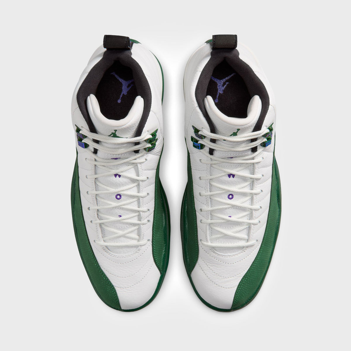 Top-down view of Air Jordan 12 Retro pair showing purple Jordan Wings embroidery and green pull tab