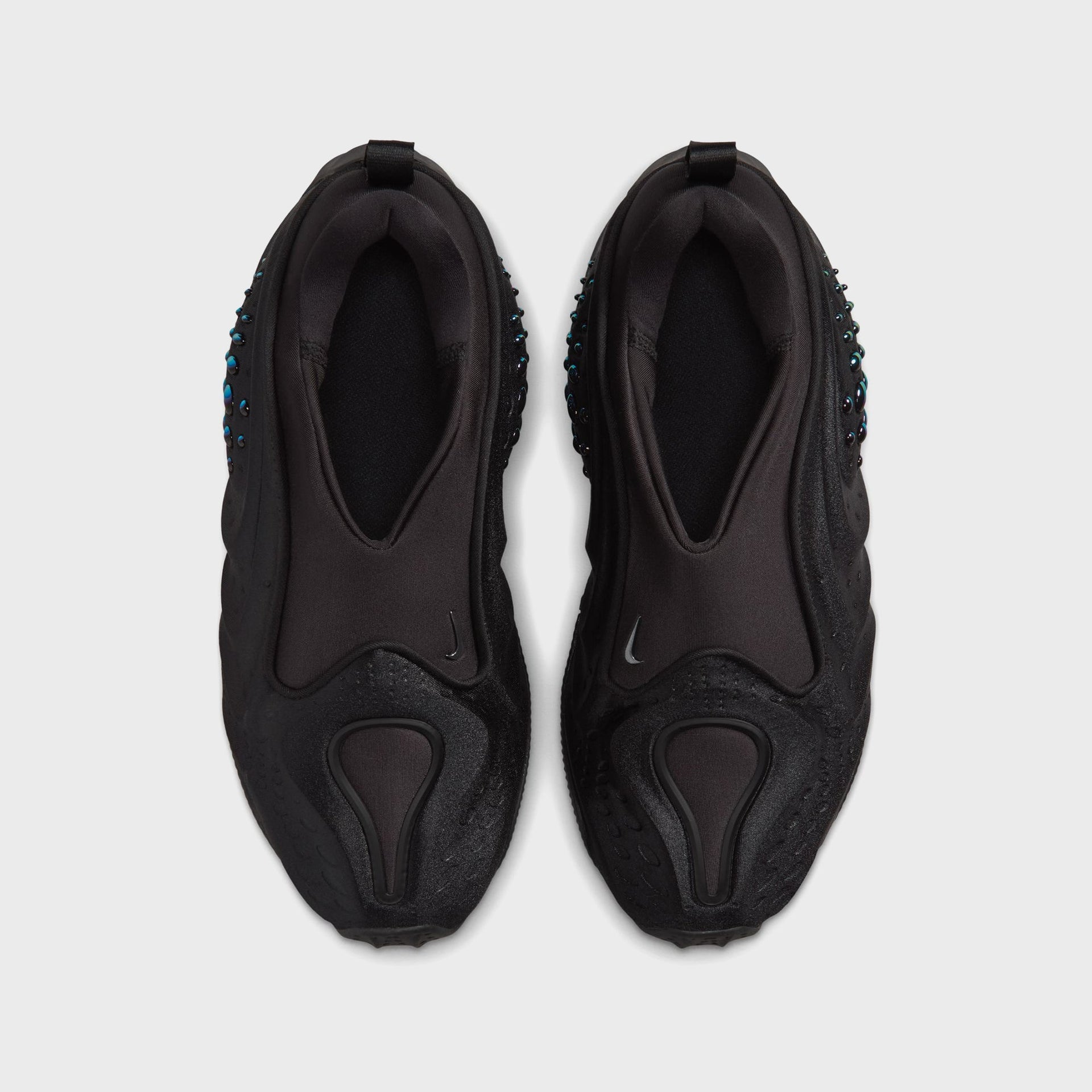 Nike WMNS First Sight Shadow Triple Black, top-down view of the laceless slip-on pair with collar openings and black heel tabs