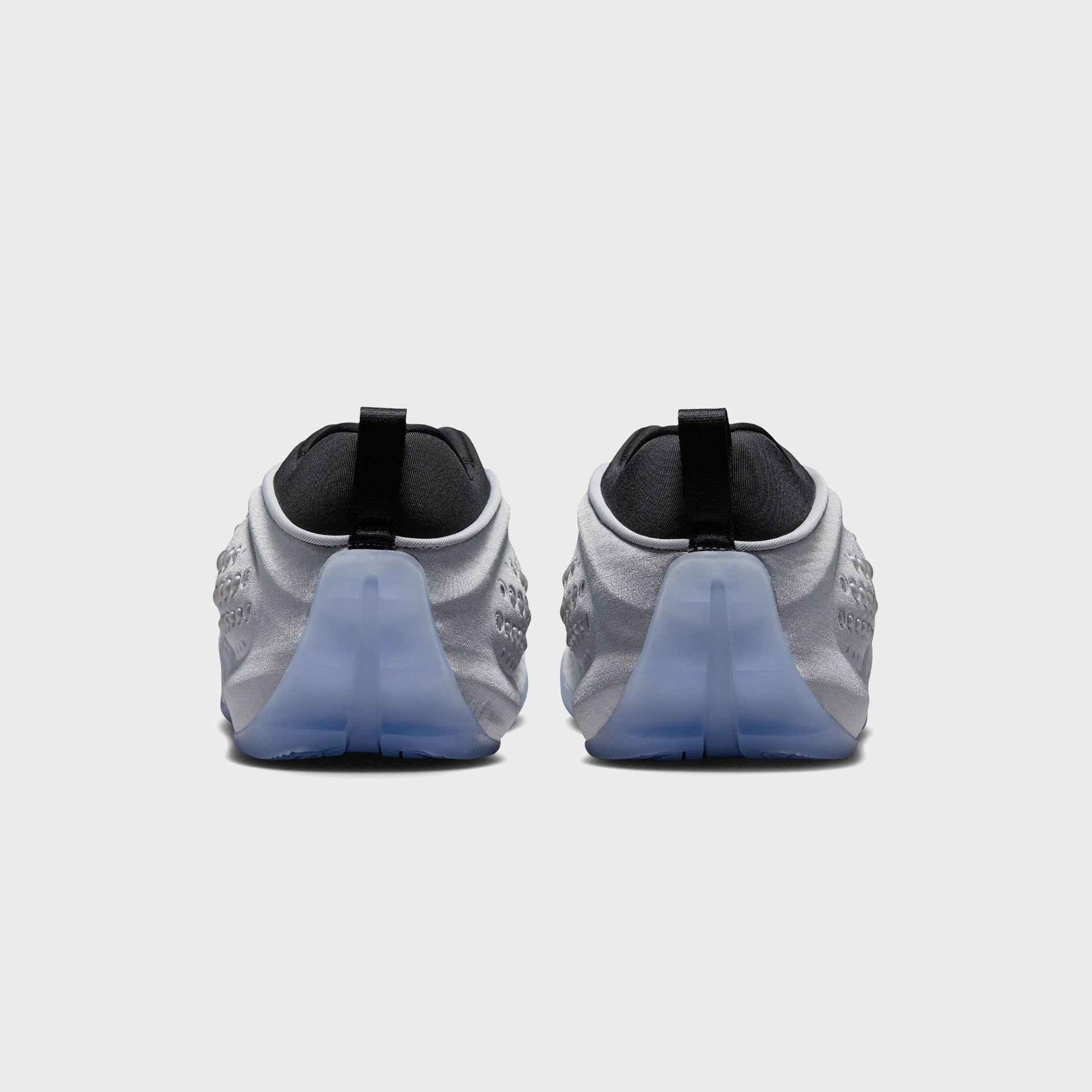 Nike WMNS First Sight Shadow Metallic Silver, rear view of the pair with black heel tabs and icy translucent blue heel soles