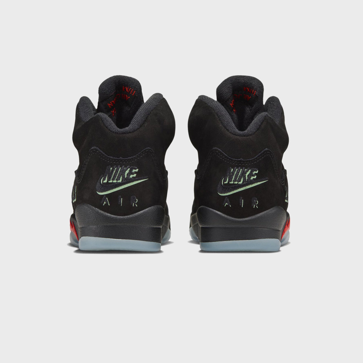 Rear view of Jordan GS Air Jordan 5 Retro black with green Nike Air heel branding and icy sole