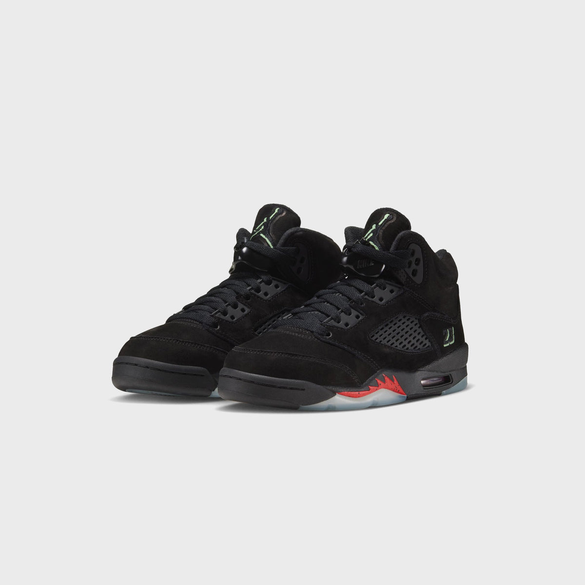 Pair of Jordan GS Air Jordan 5 Retro black suede sneakers, three-quarter front view with glow-in-the-dark green accents