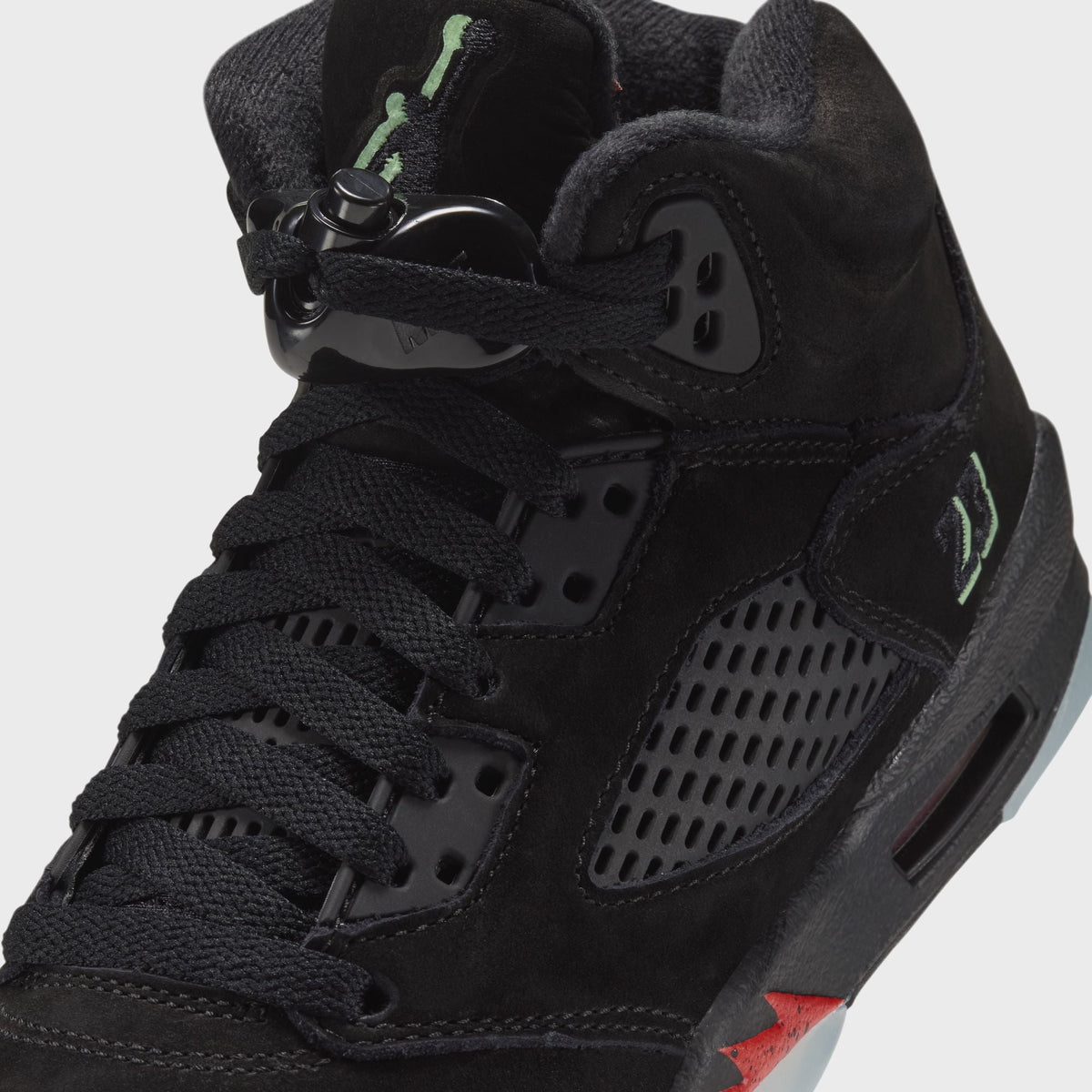 Close-up of Jordan GS Air Jordan 5 Retro lacing, lace lock and green embroidered 23 on black suede ankle panel
