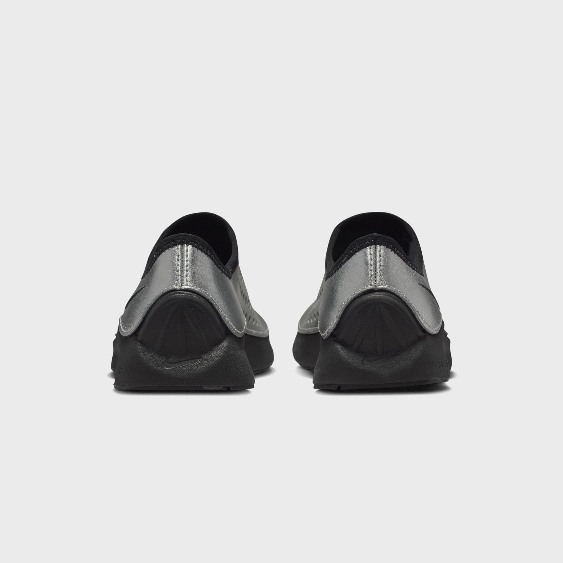 Nike Aurora slip-on sneakers in metallic silver and black, heel view at Kith