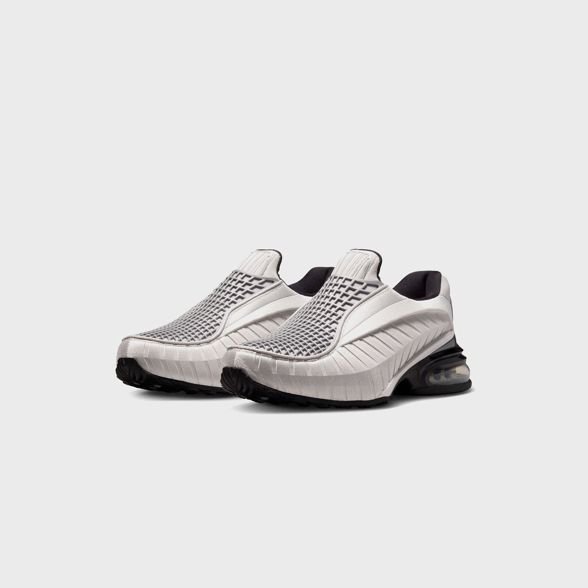 Nike Air Max Dolce sneakers in Metallic Silver and Black, front three-quarter view of the pair on a slip-on silhouette