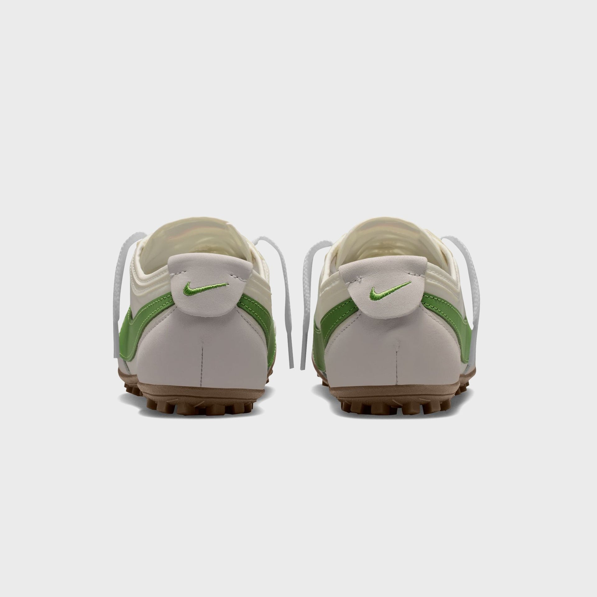 Nike WMNS Moon Shoe rear heel view of the pair, green embroidered Swoosh on suede heel tabs above gum soles
