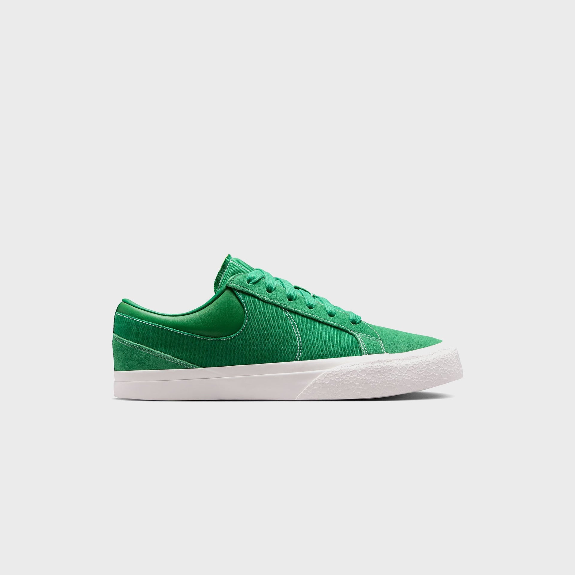 Nike Blazy in Pine Green, lateral profile of a low-top with green suede toe, canvas panel, tonal Swoosh and white sail sole