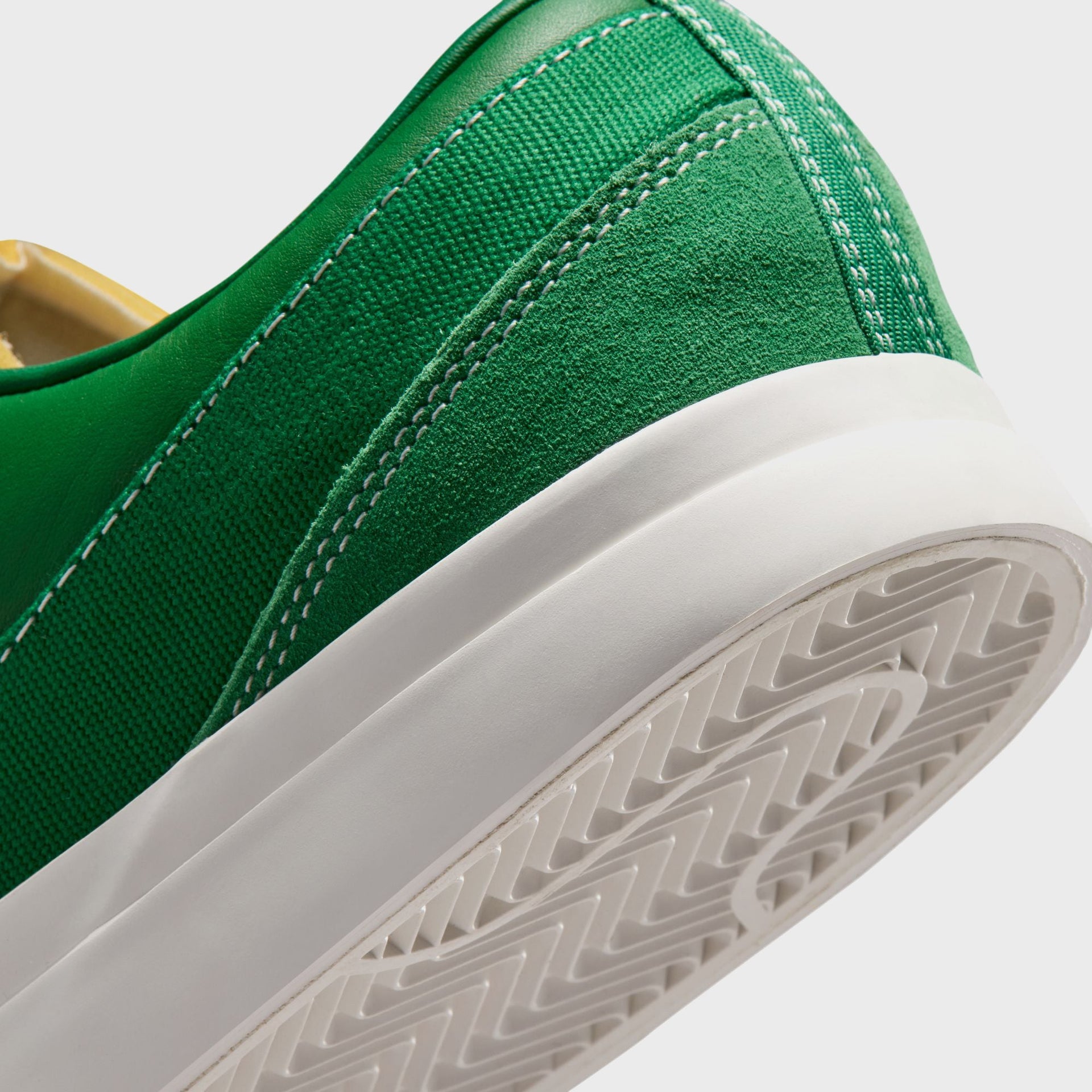 Close-up of the Nike Blazy Pine Green heel in suede and canvas with white stitching, sail midsole and translucent herringbone outsole