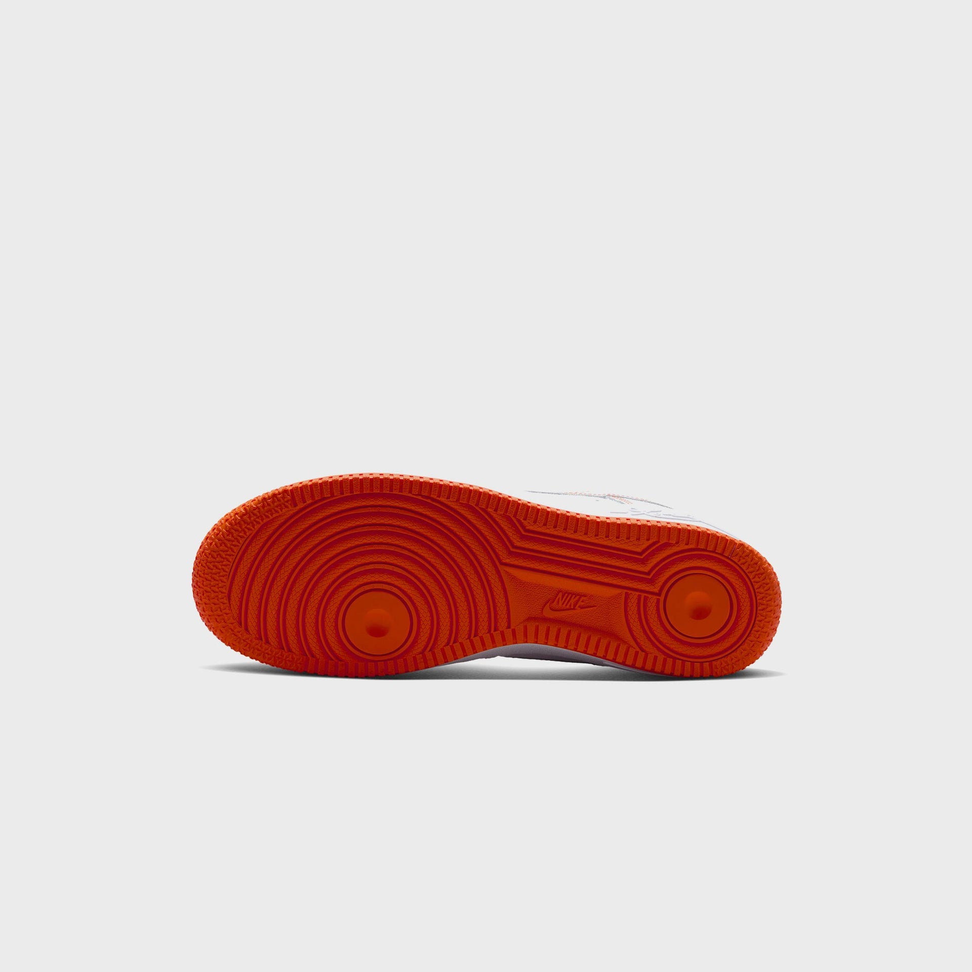 Bottom outsole of the Nike AF1 Low Protro NYC in safety orange with concentric circles and embossed Nike branding