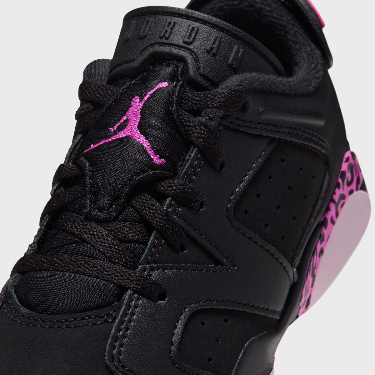 Close-up of Air Jordan 6 Retro Low PS black lace area with pink Jumpman tongue logo and JORDAN tongue lettering