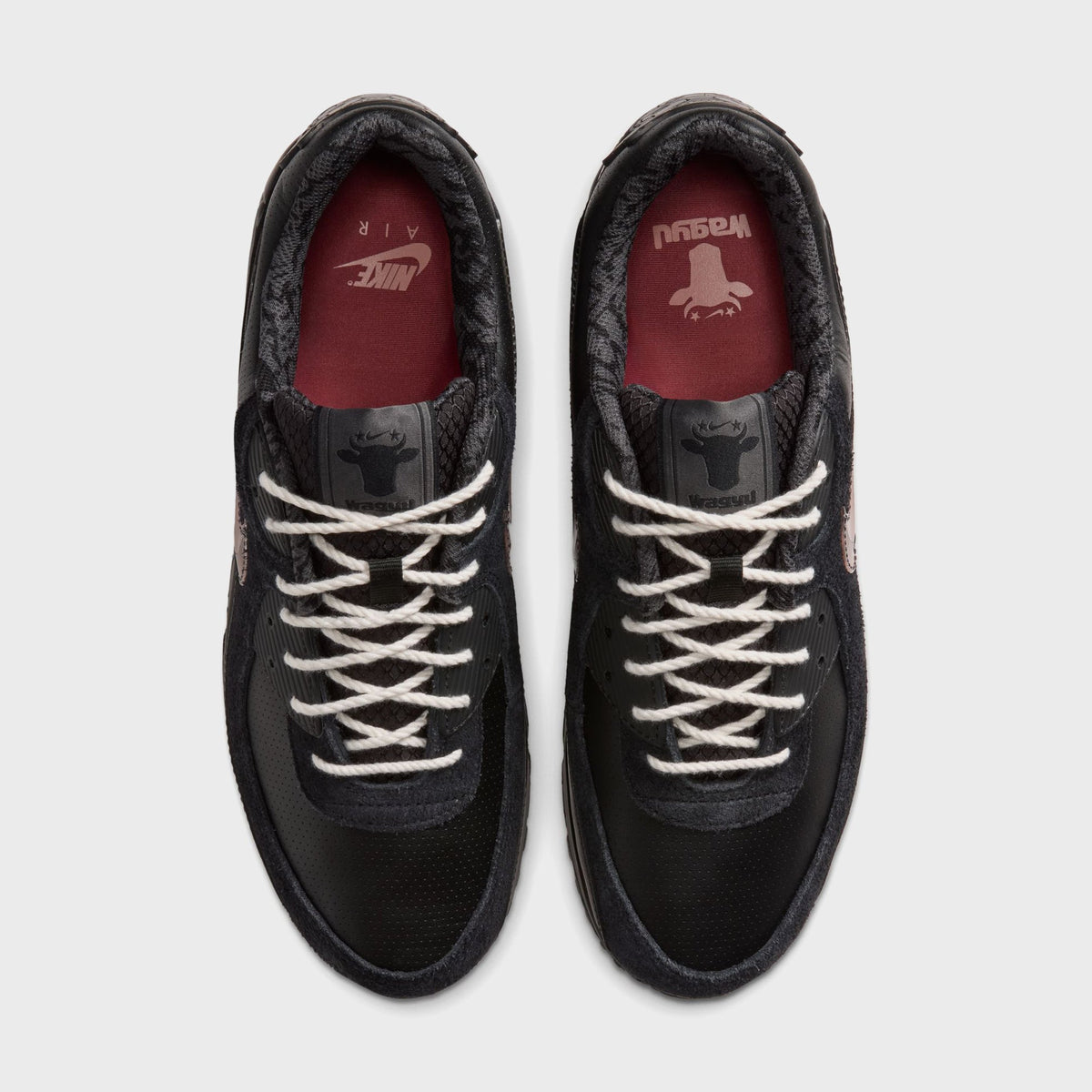 Top-down view of Nike x Wagyu Air Max 90 pair showing burgundy Wagyu cattle-head branded insoles