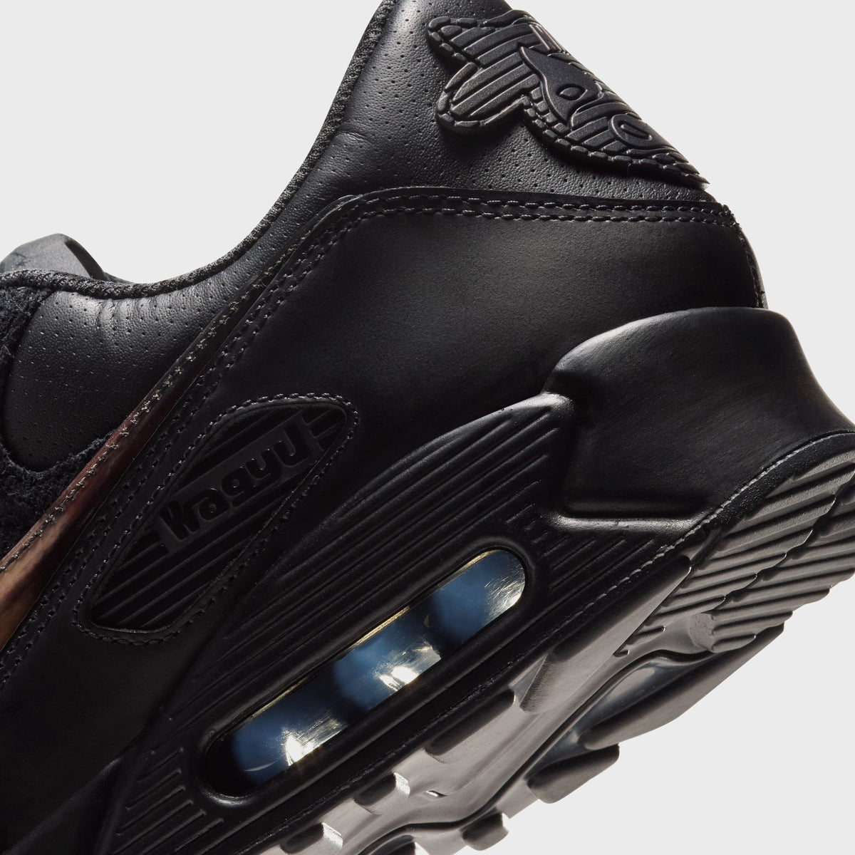 Close-up of Nike x Wagyu Air Max 90 forefoot showing marbled tortoiseshell swoosh and Wagyu wordmark on the midsole