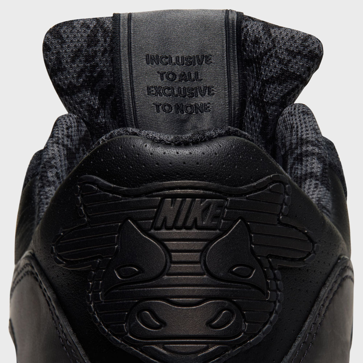Close-up of Nike x Wagyu Air Max 90 heel pull tab reading Inclusive To All, Exclusive To None above cattle-head graphic