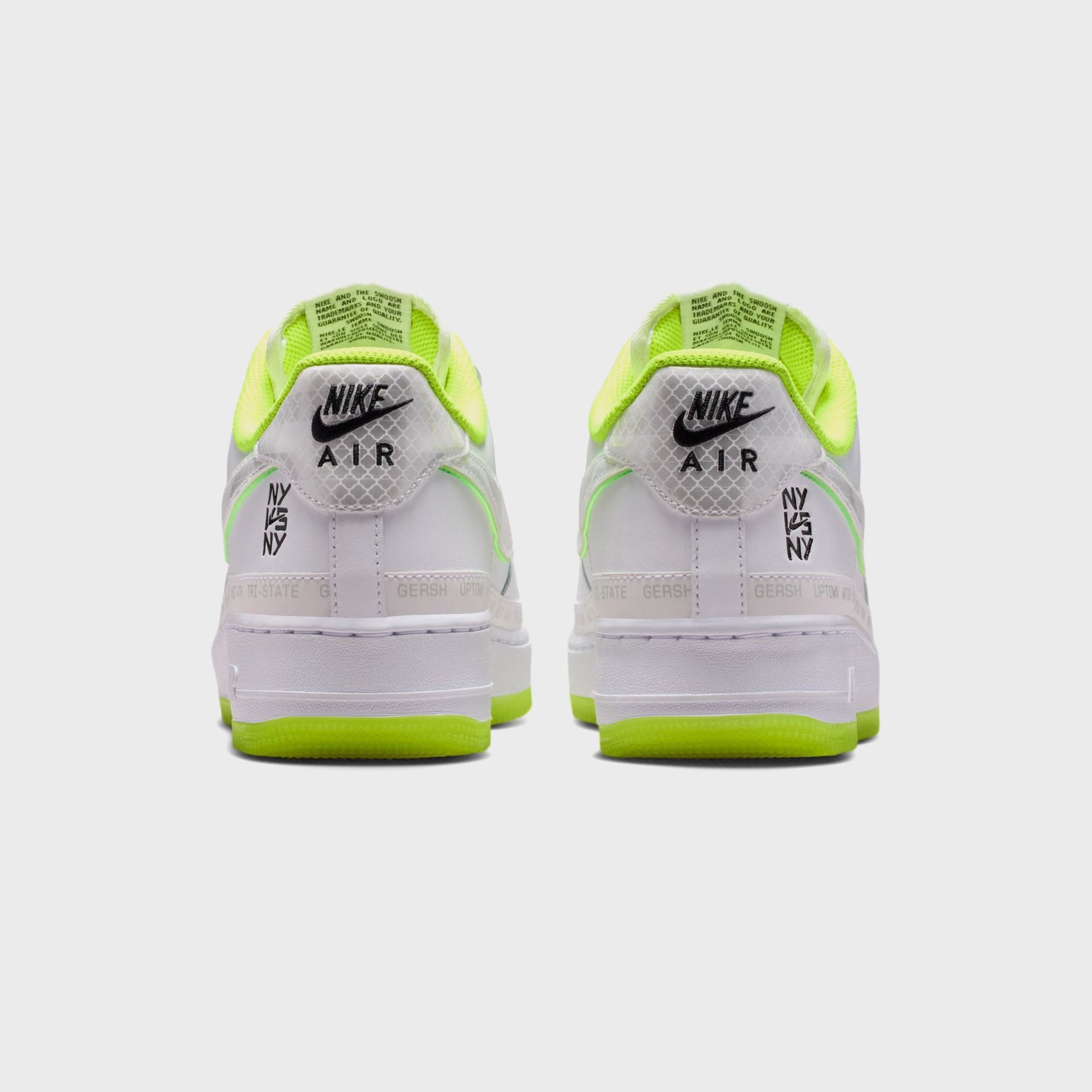 Nike Air Force 1 '07 pair rear view, white grid-textured heels with Nike Air logo, black NY vs NY print and volt outsoles