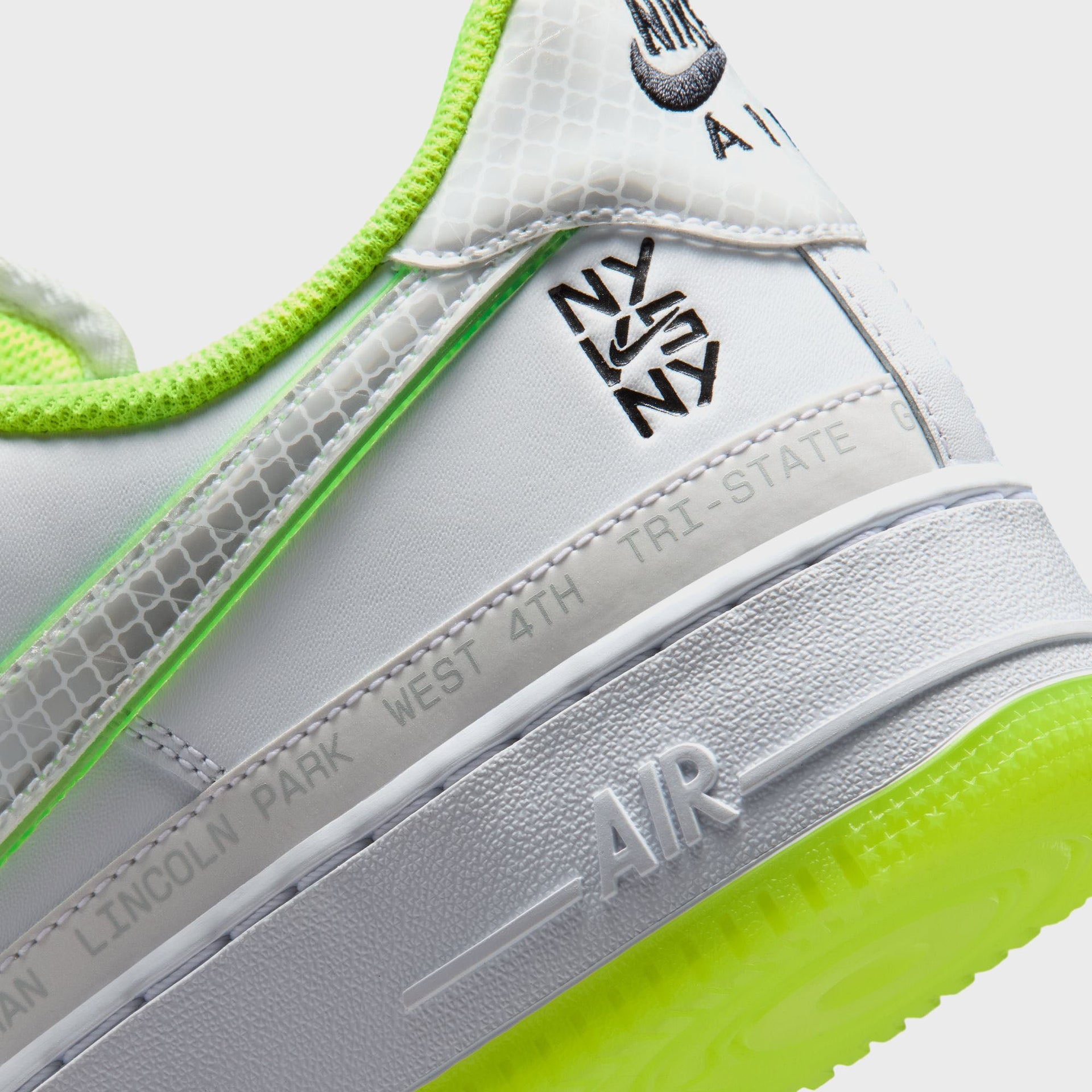 Nike Air Force 1 '07 heel detail: black NY vs NY logo, grey neighborhood-name midsole tape and embossed AIR on the volt translucent sole