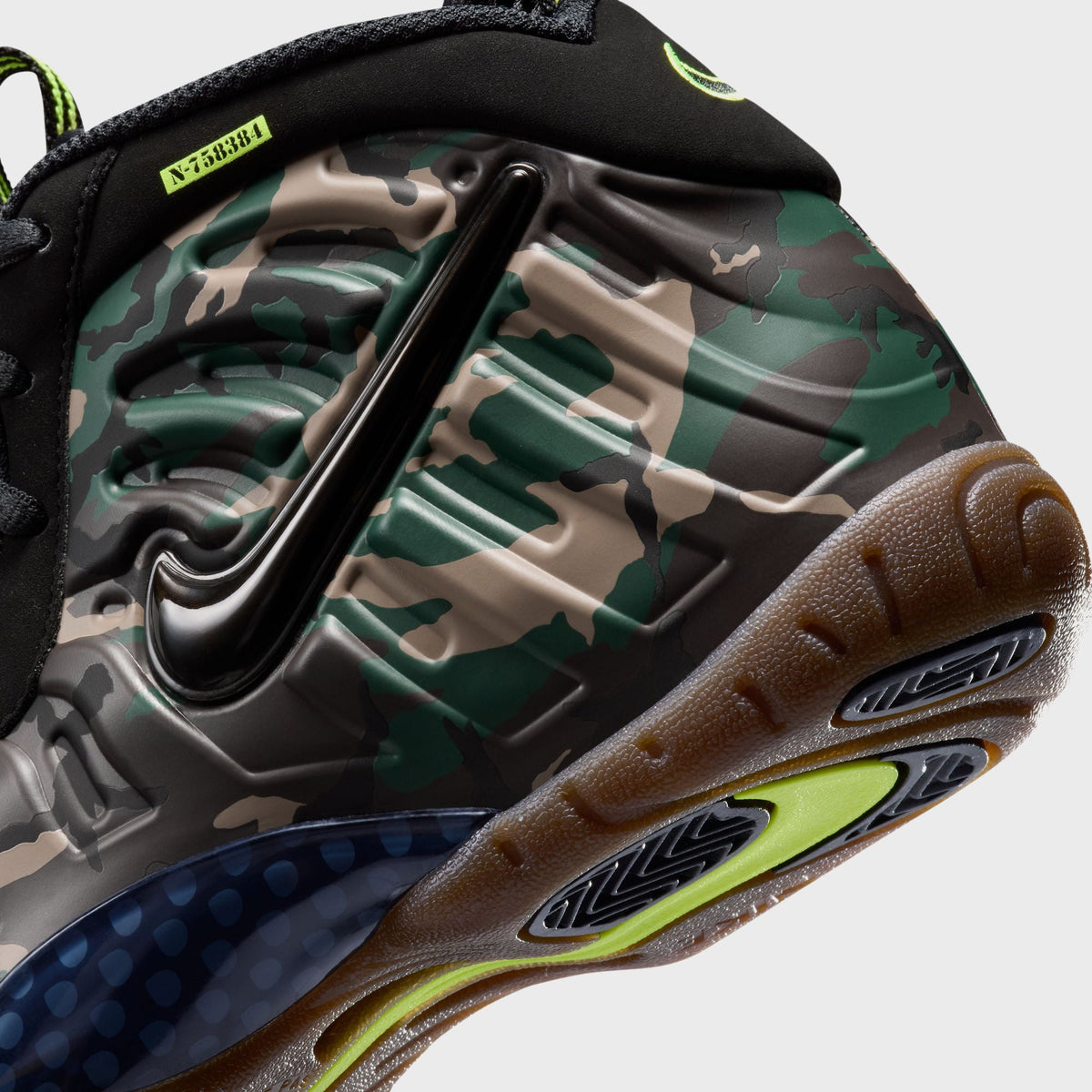 Close-up of Nike GS Little Posite Pro heel showing navy dot-textured panel and camo foam shell