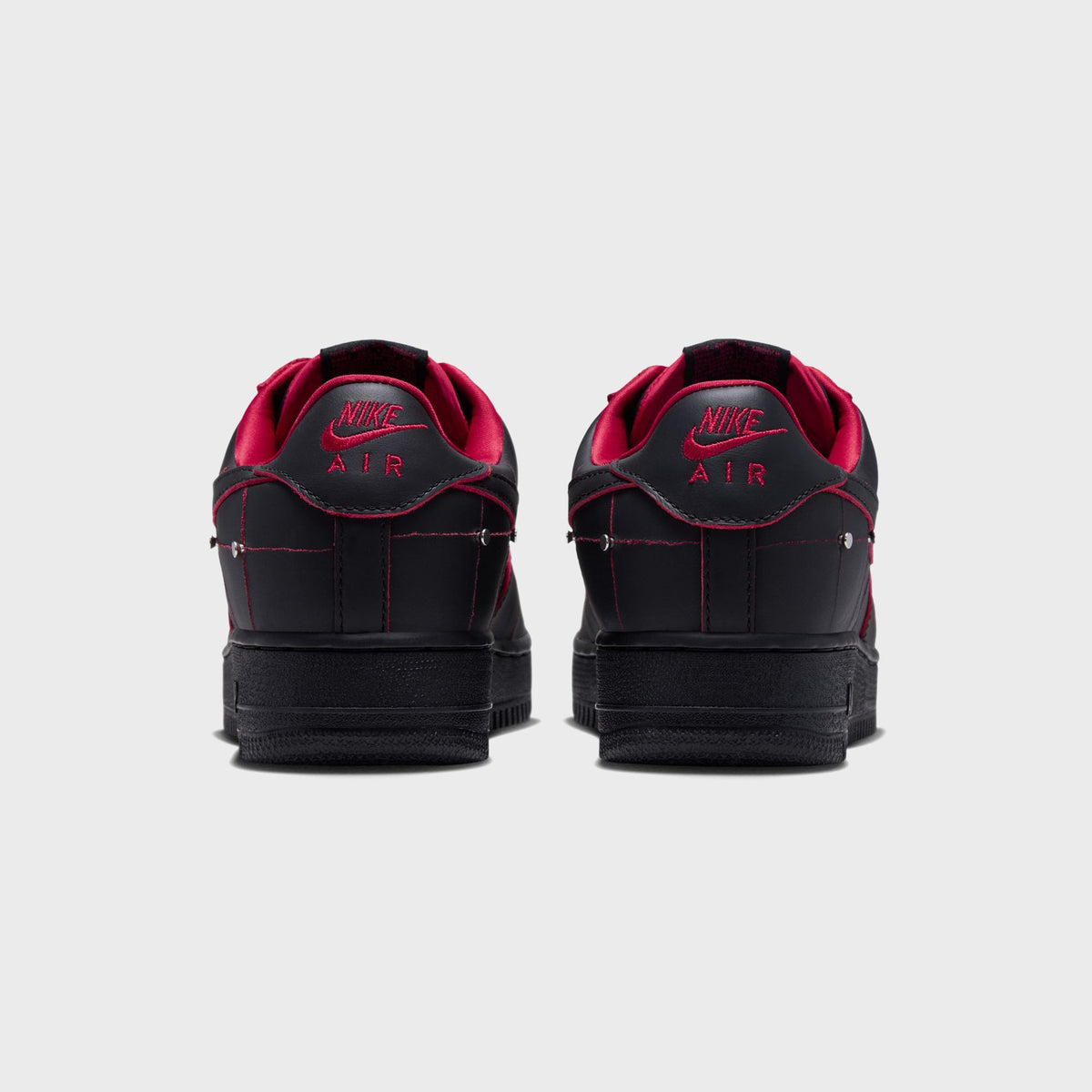 Rear view of black Nike Air Force 1 '01 sneakers with red 'NIKE AIR' heel branding