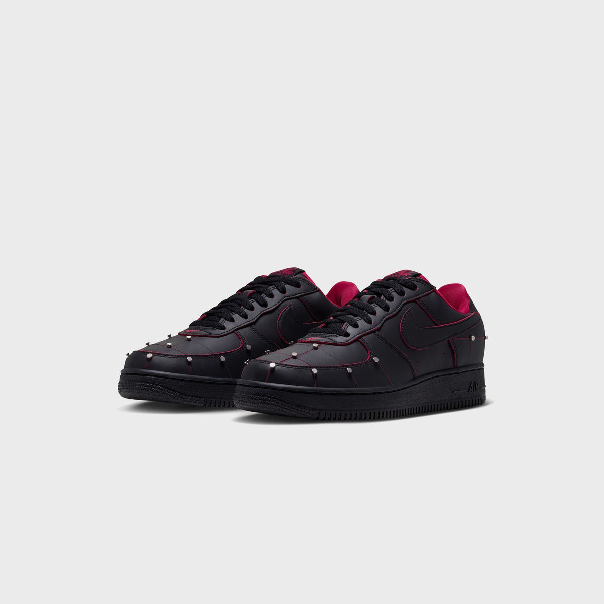 Pair of black Nike Air Force 1 '01 sneakers with red accents, front three-quarter view