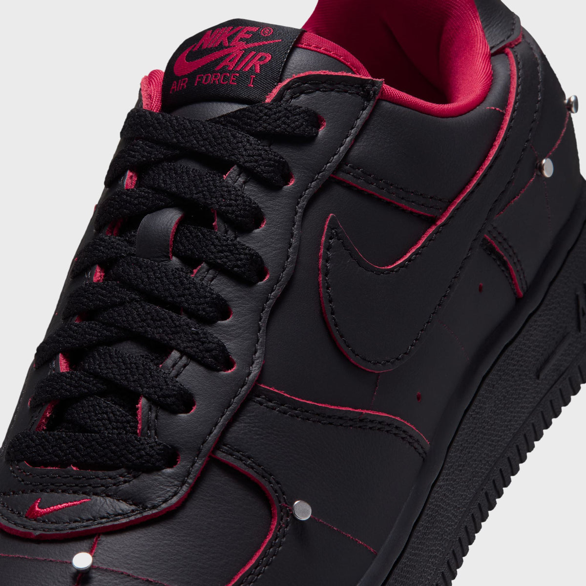 Close-up of the black Air Force 1 toe and laces with red swoosh and 'Air Force 1' text