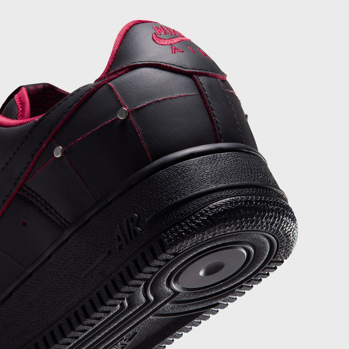 Close-up of the black Air Force 1 '01 heel with silver studs and red stitching