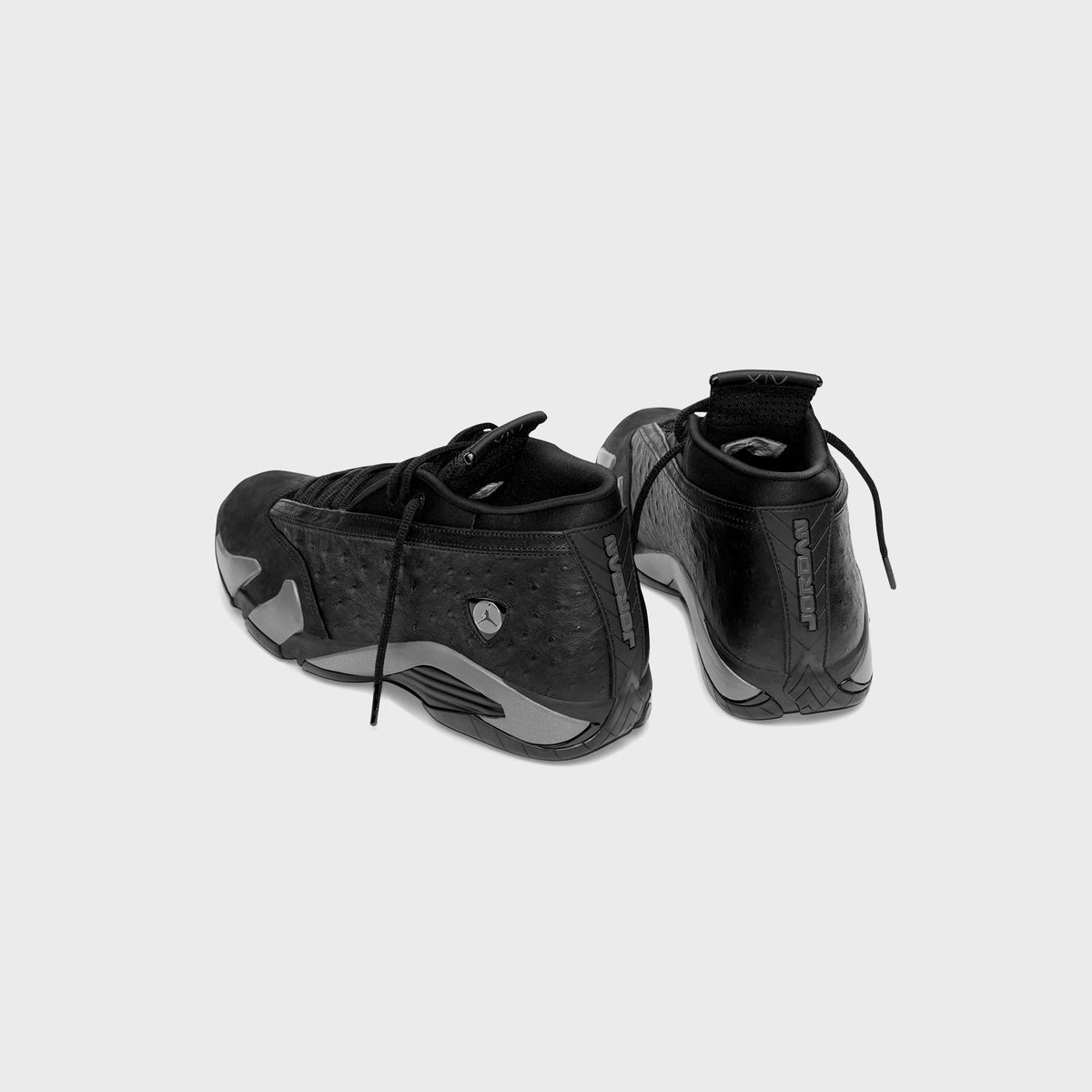 Air Jordan 14 Low pair in black, rear three-quarter view showing heel tabs, JORDAN heel lettering and ostrich-texture quarter
