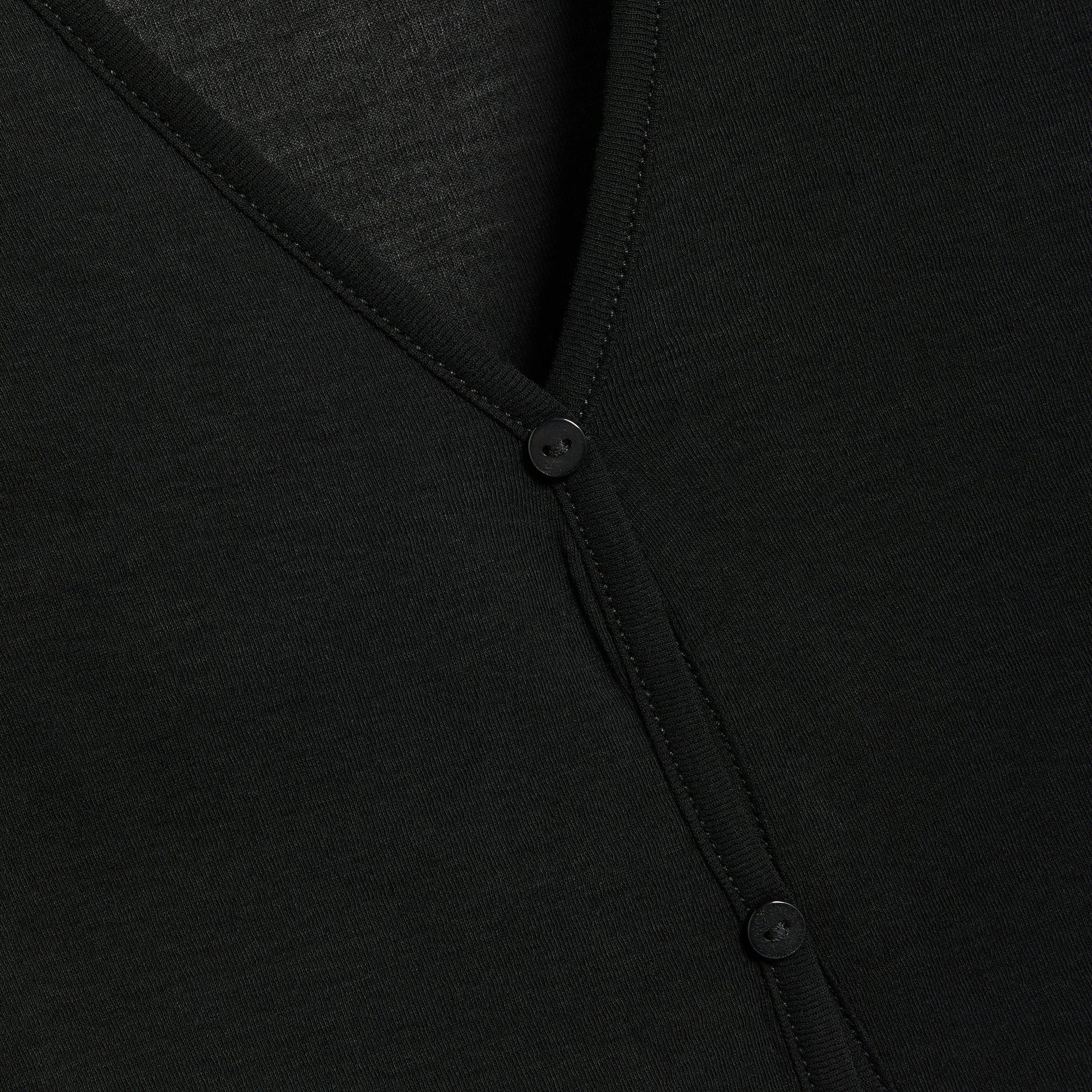 Bond-Eye Elias black dress detail, close-up of V-neck buttons and tie placket